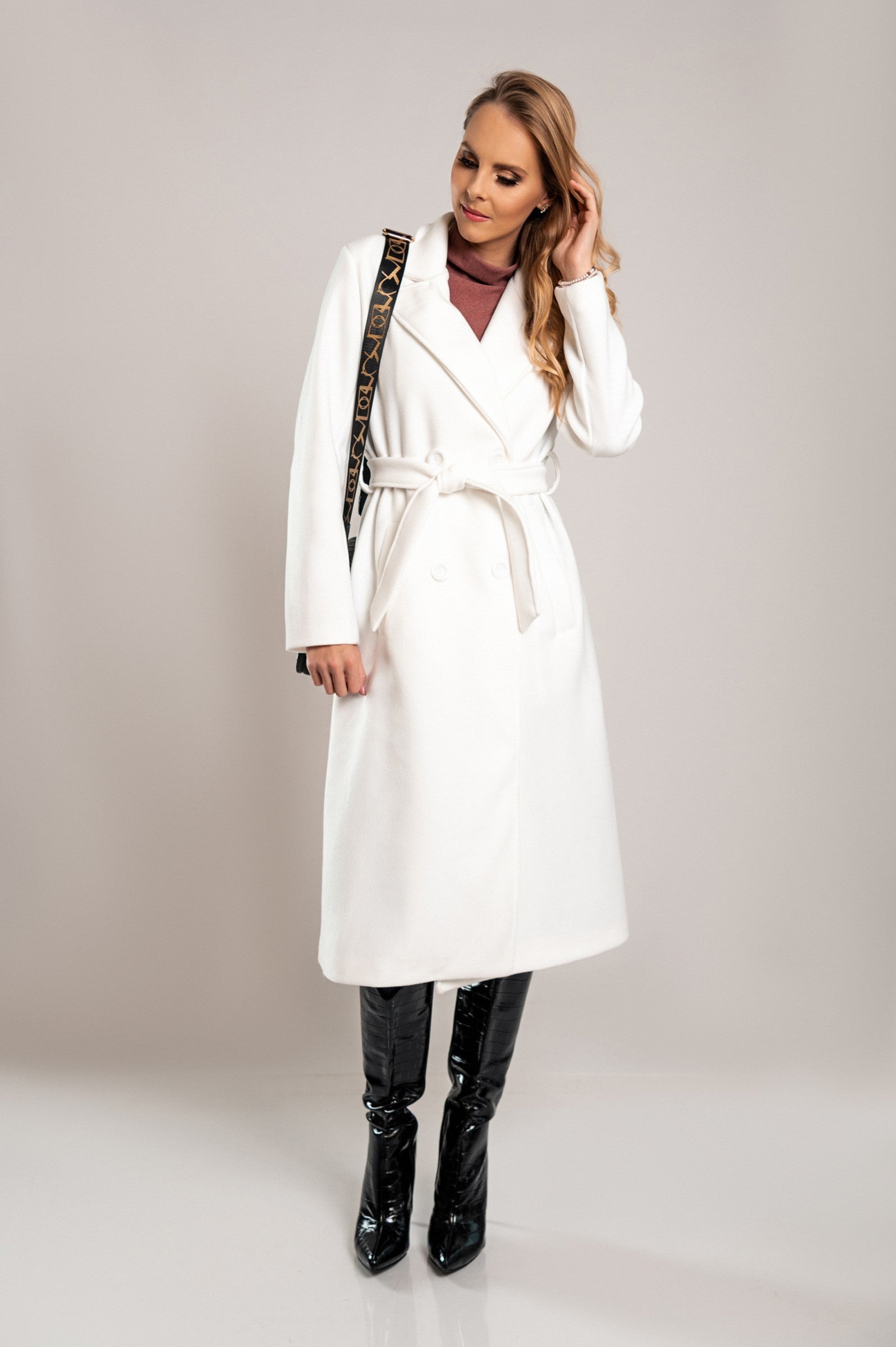 Elegant long white coat with buttons, featuring a classic collar and decorative belt, made from high-quality soft fabric.