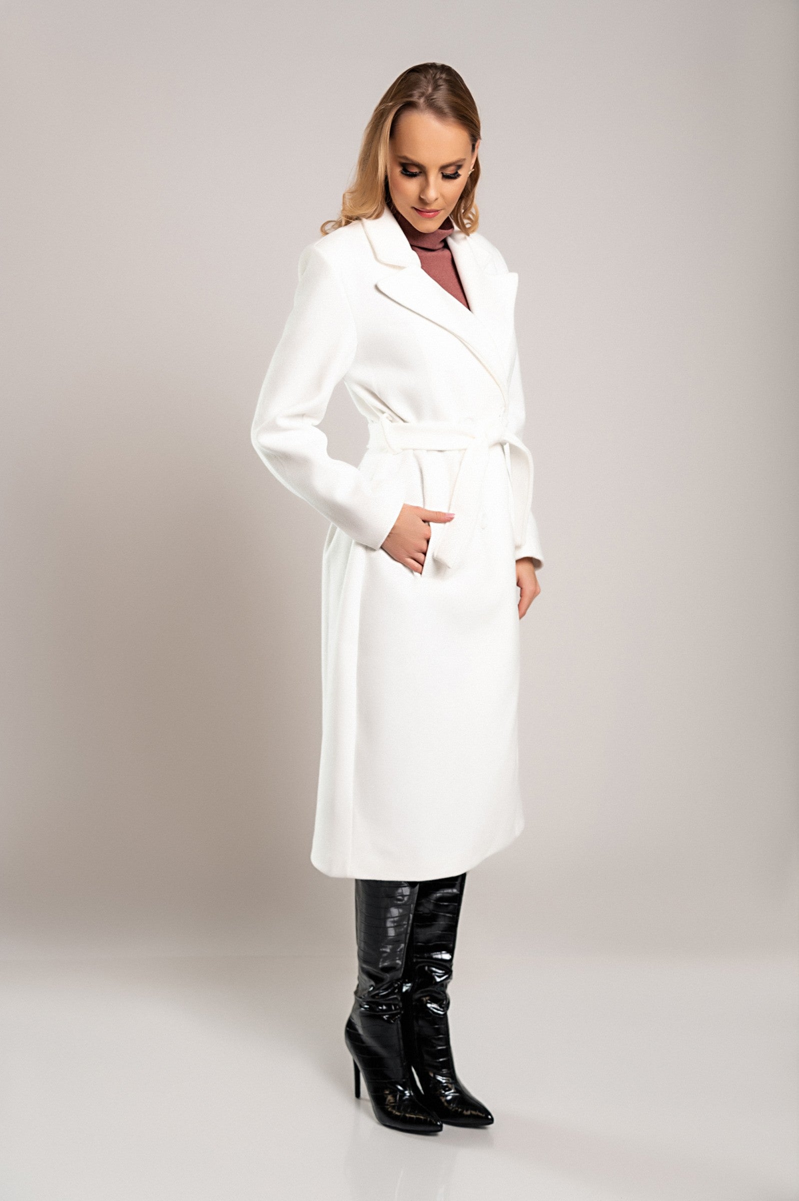 Elegant long white coat with buttons, featuring a classic collar and decorative belt, made from high-quality soft fabric.