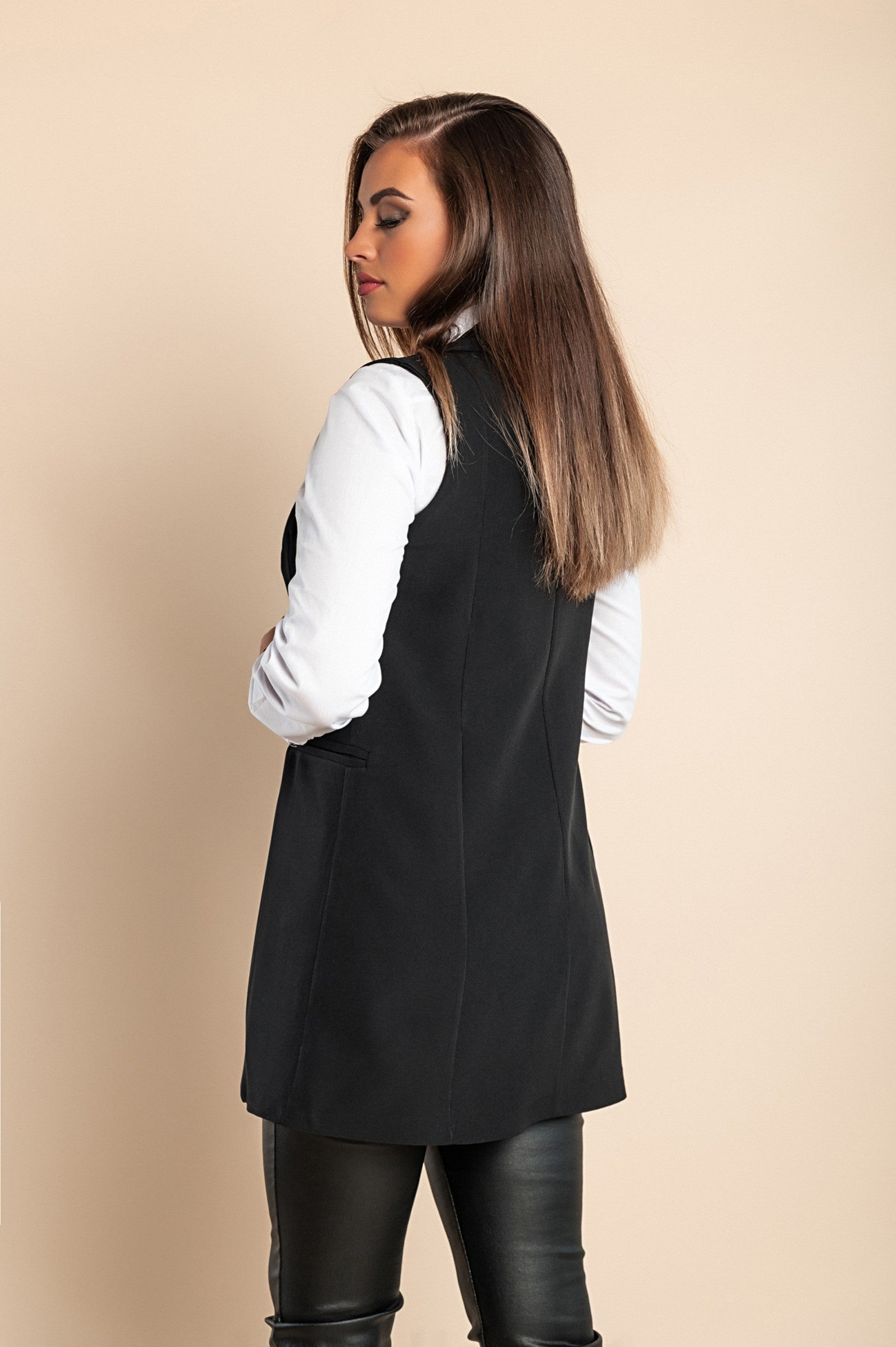 Elegant long black vest with button closure, featuring a V-neckline, classic collar, and decorative side pockets.