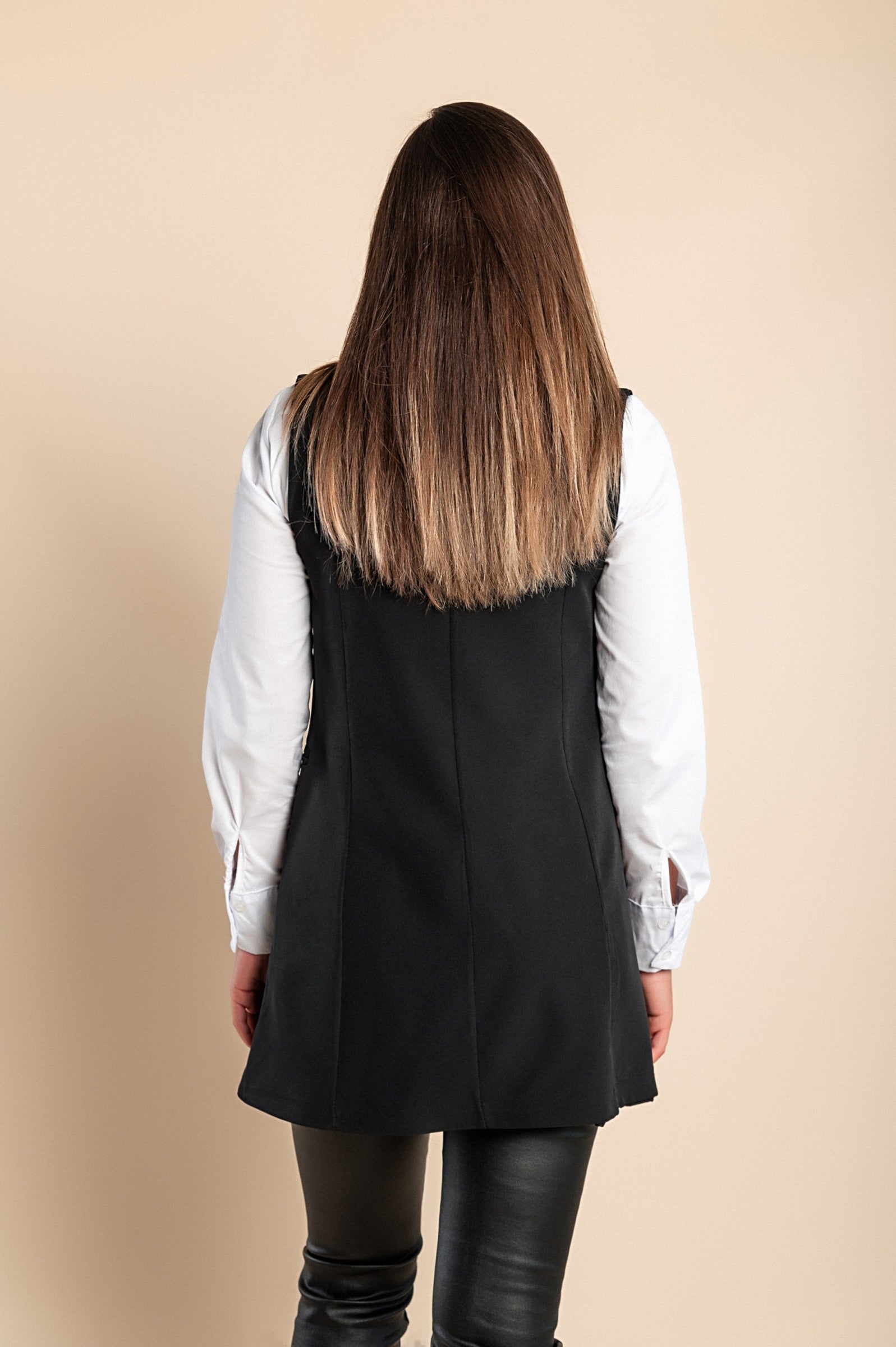 Elegant long black vest with button closure, featuring a V-neckline, classic collar, and decorative side pockets.