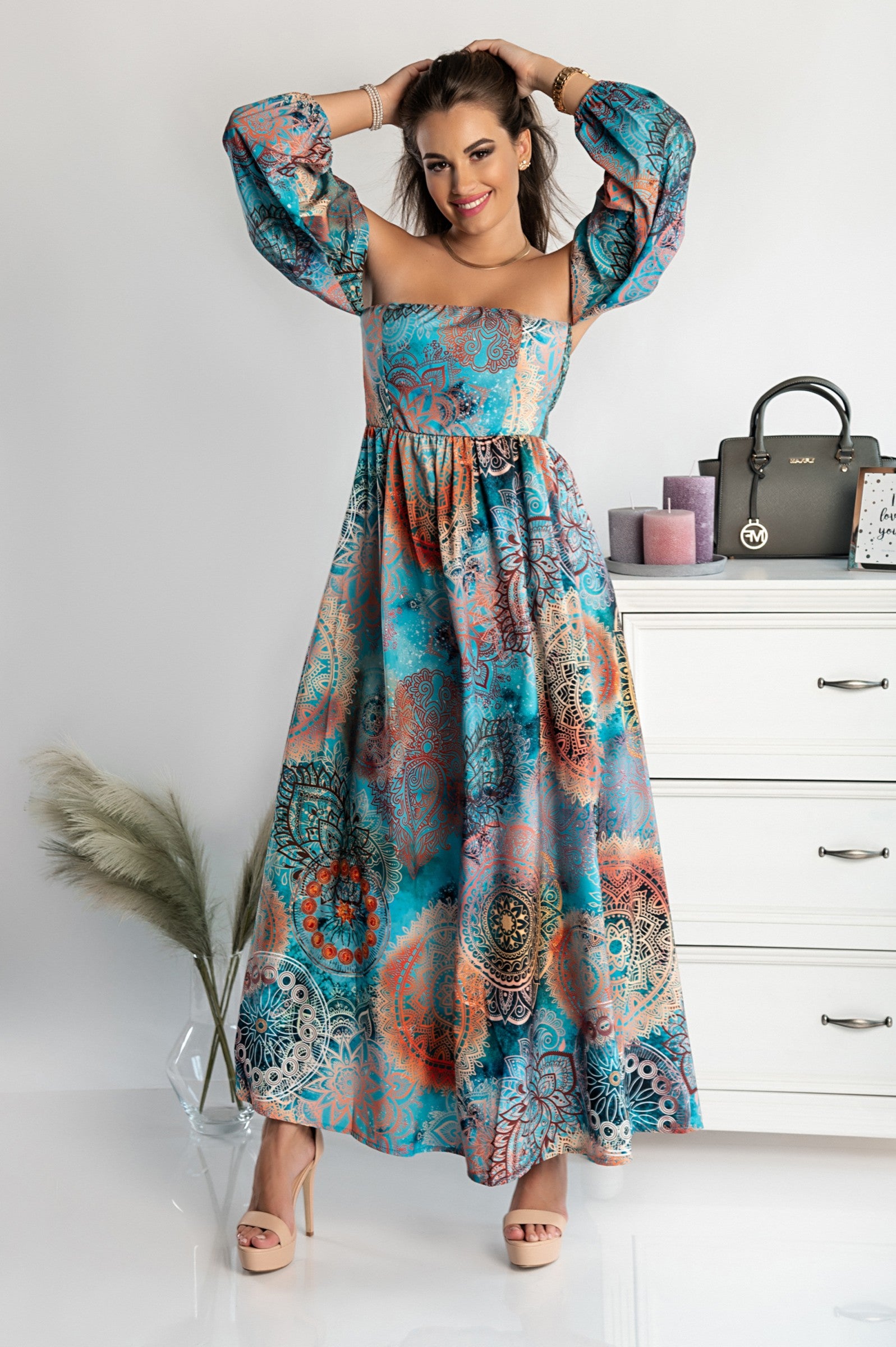 Elegant light blue maxi dress with print Montella featuring long sleeves, straight neckline, and a loose cut skirt with a front opening.