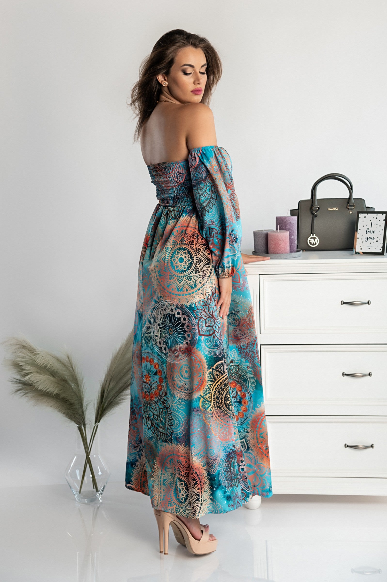 Elegant light blue maxi dress with print Montella featuring long sleeves, straight neckline, and a loose cut skirt with a front opening.