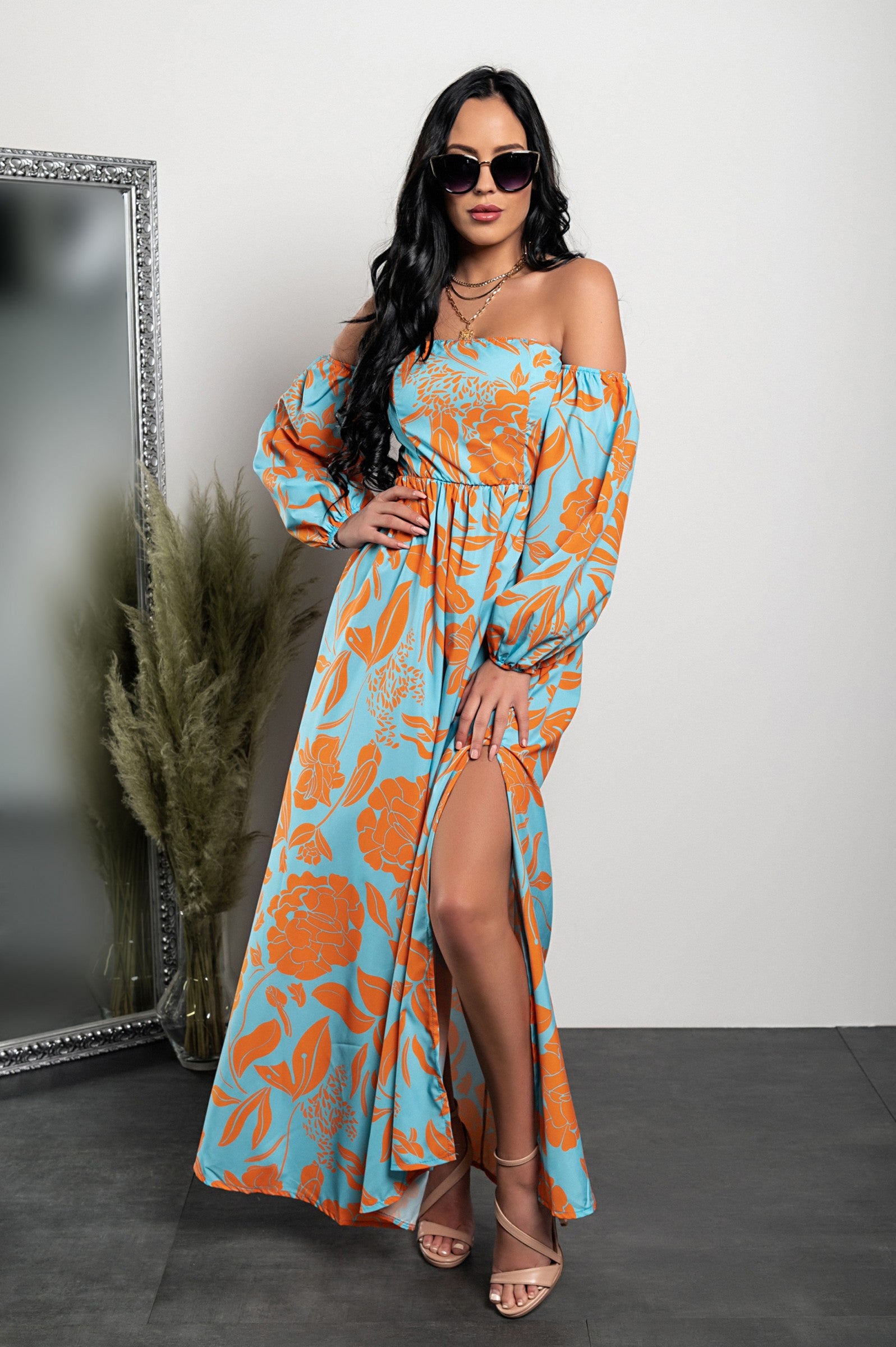 Elegant orange maxi dress with print, featuring a straight neckline, long sleeves, and a loose-cut skirt with a front opening.