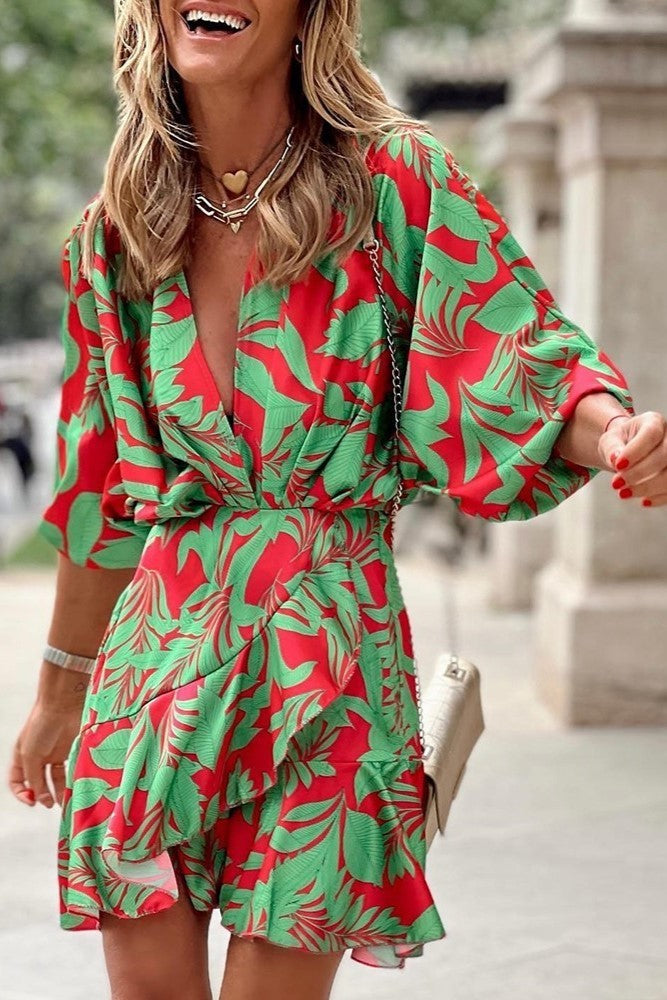 Elegant green mini dress with print, featuring a deep neckline, short sleeves, and a decorative belt, designed for comfort and style.