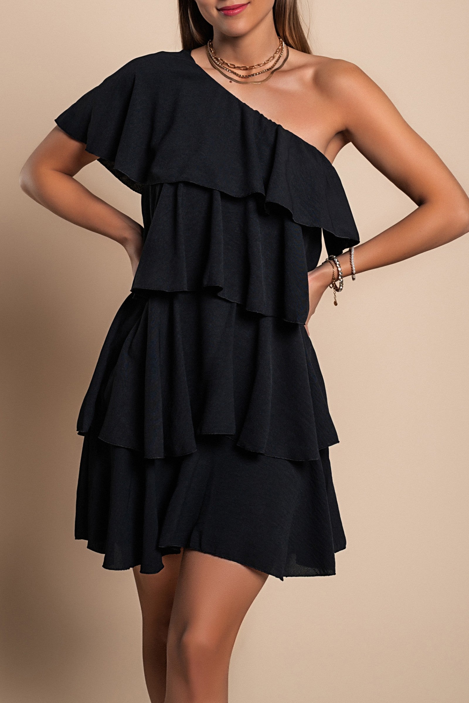 Elegant black mini dress with ruffles, featuring an asymmetrical neckline and one strap, designed for comfort and style.