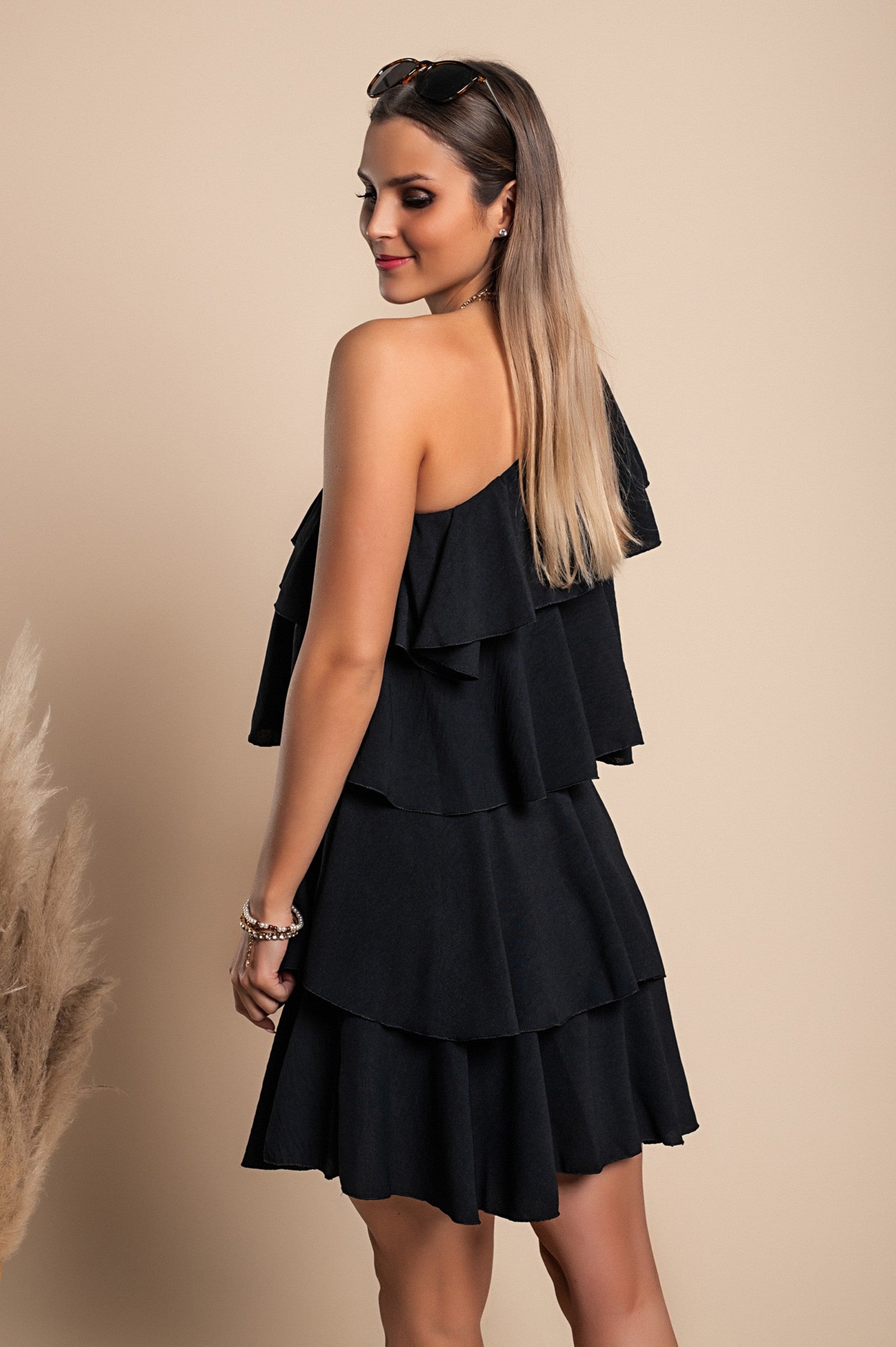 Elegant black mini dress with ruffles, featuring an asymmetrical neckline and one strap, designed for comfort and style.