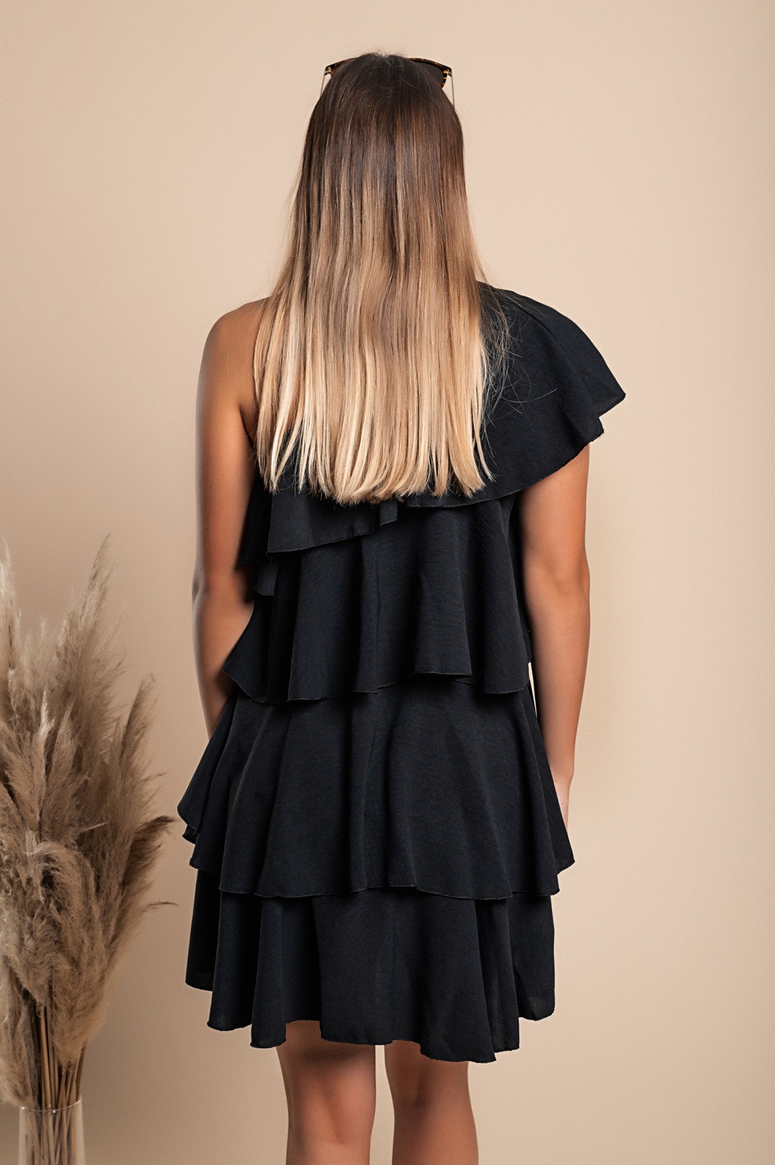 Elegant black mini dress with ruffles, featuring an asymmetrical neckline and one strap, designed for comfort and style.