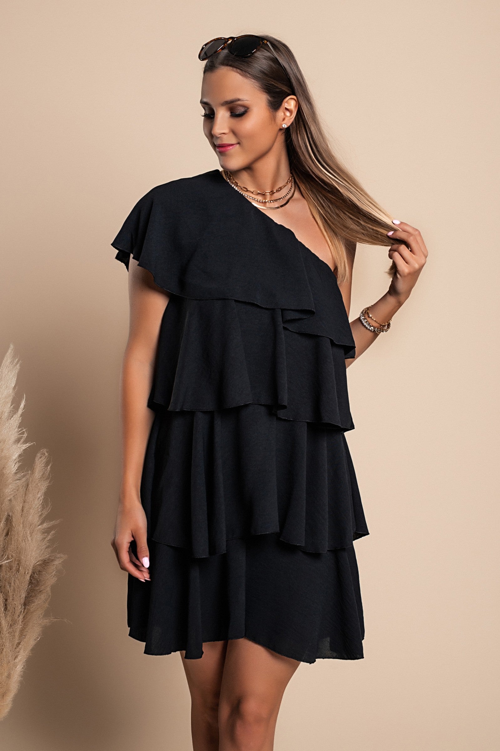 Elegant black mini dress with ruffles, featuring an asymmetrical neckline and one strap, designed for comfort and style.