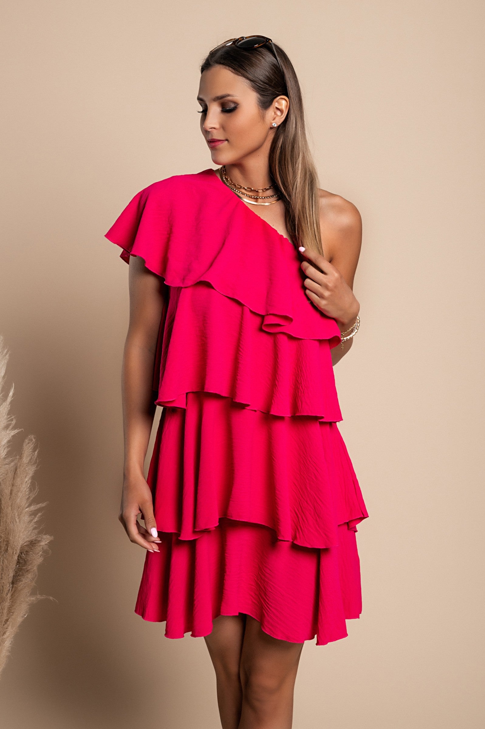 Elegant pink mini dress with ruffles, featuring an asymmetrical neckline and one strap, made from soft polyester fabric.