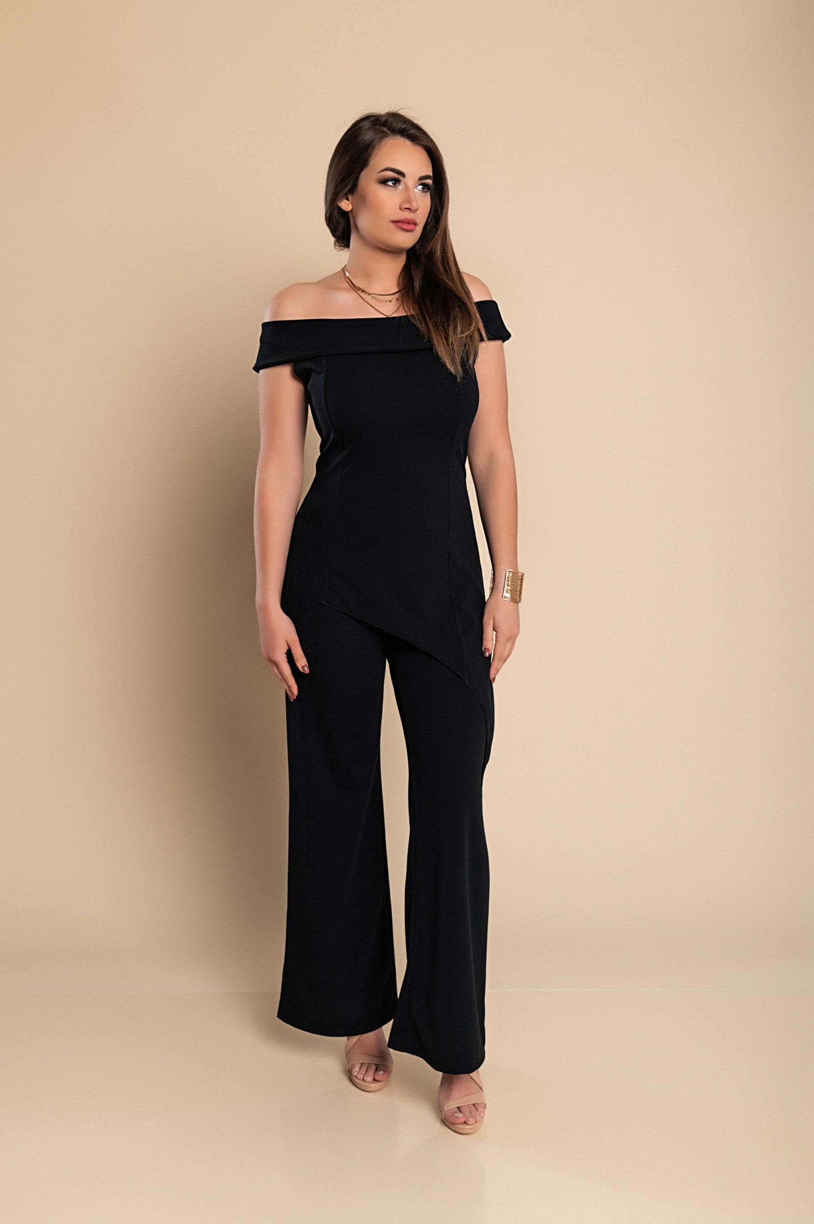 Elegant black asymmetrical top with short sleeves and loose trousers, showcasing a modern and stylish outfit.