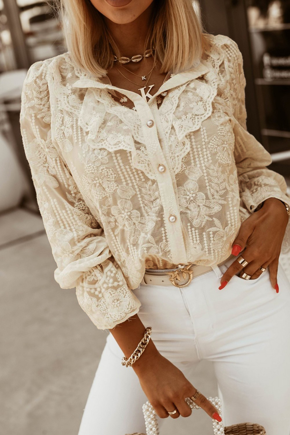 Elegant beige shirt with embroidery and frills, featuring long sleeves and a button closure, perfect for stylish outfits.