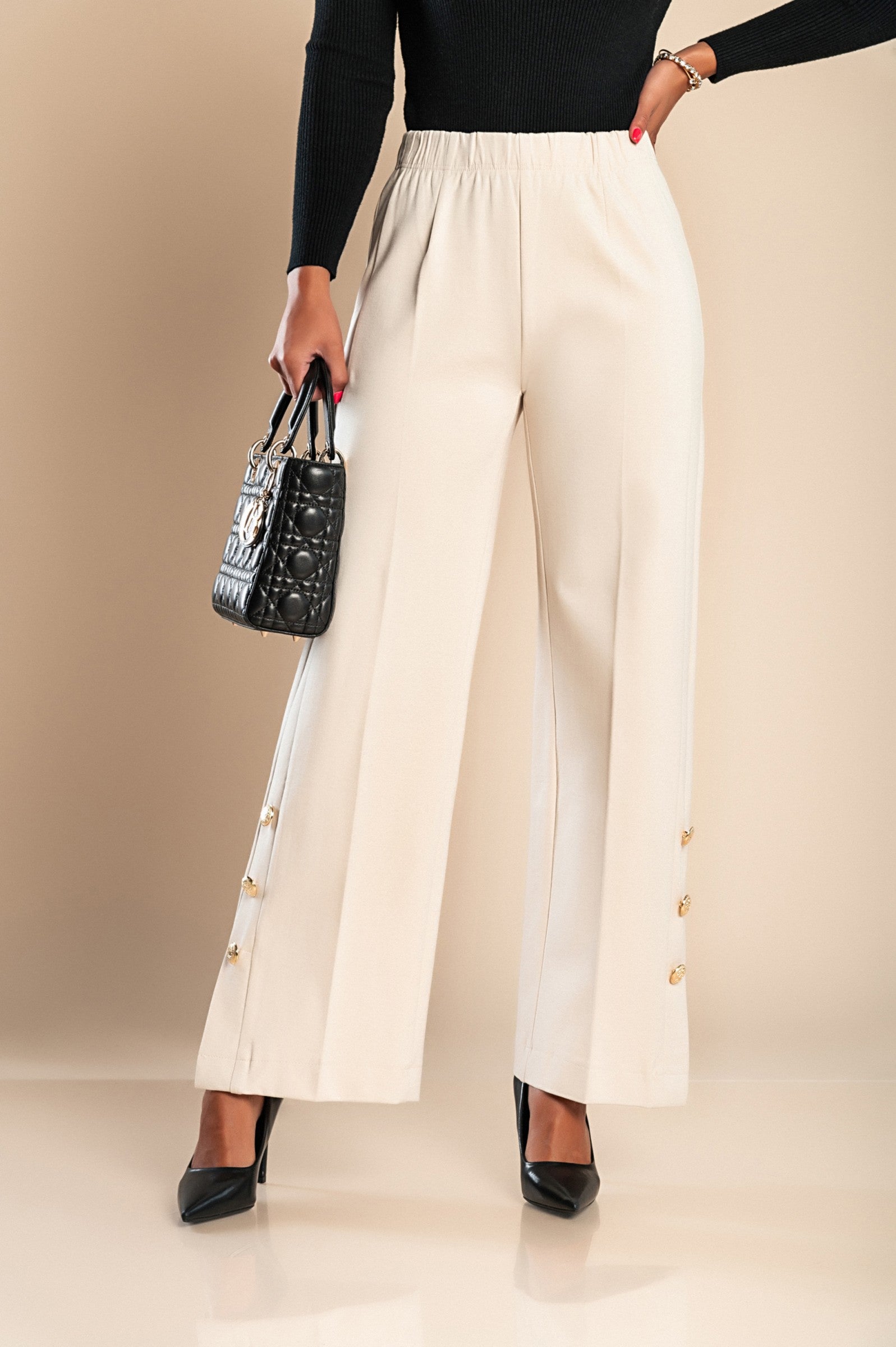 Elegant cream trousers with decorative buttons and elasticated waist, showcasing a stylish straight leg design.