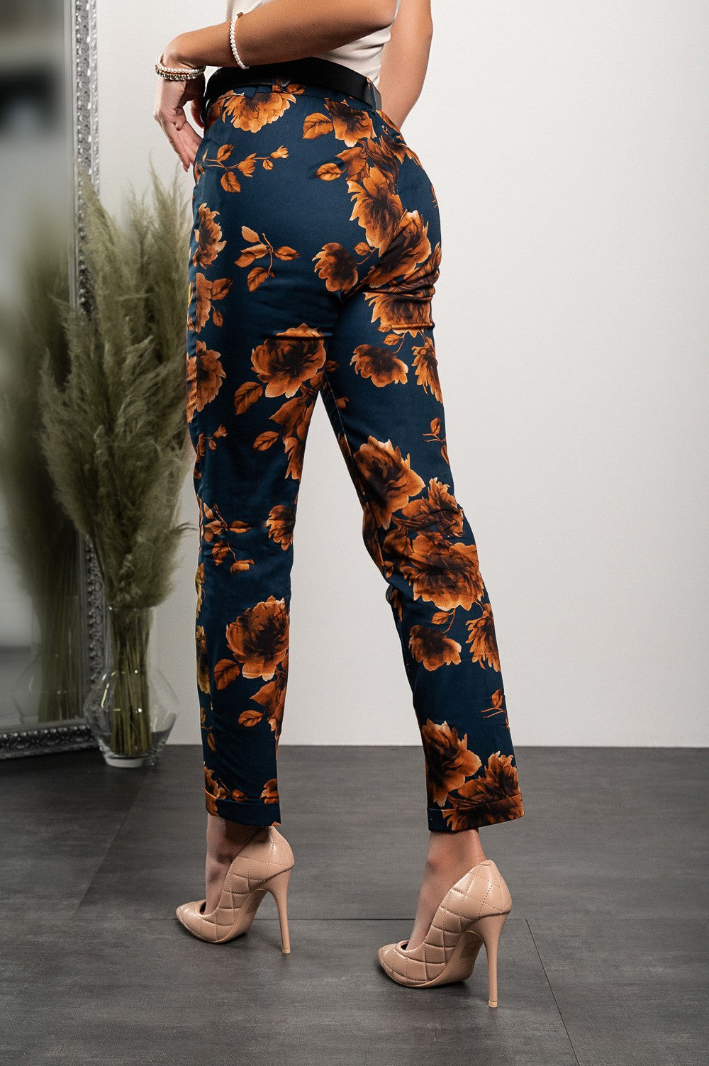 Elegant blue trousers with floral print, featuring a slim leg design and front zip and button closure, made from high-quality cotton and elastane.