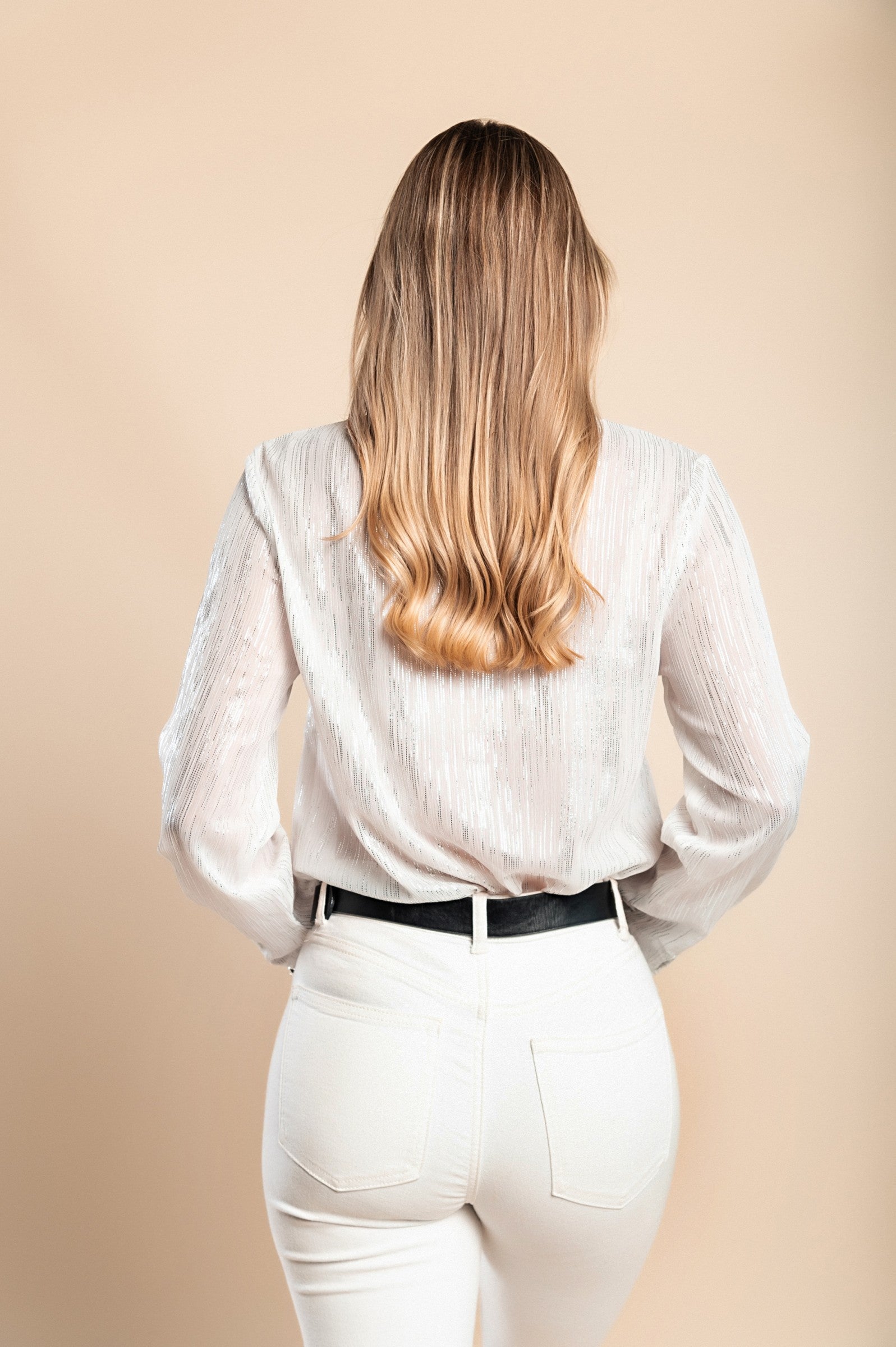 Elegantna bela bluza iz polprosojnega blaga Callafela z bleščečim potiskom in klasičnim ovratnikom.