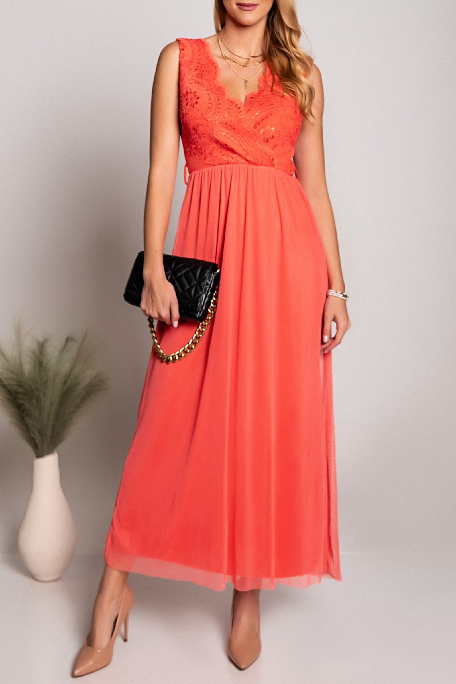 Elegantna dolga obleka z 'V' izrezom in detajlom vezenine, izdelana iz mehkega in elastičnega blaga.