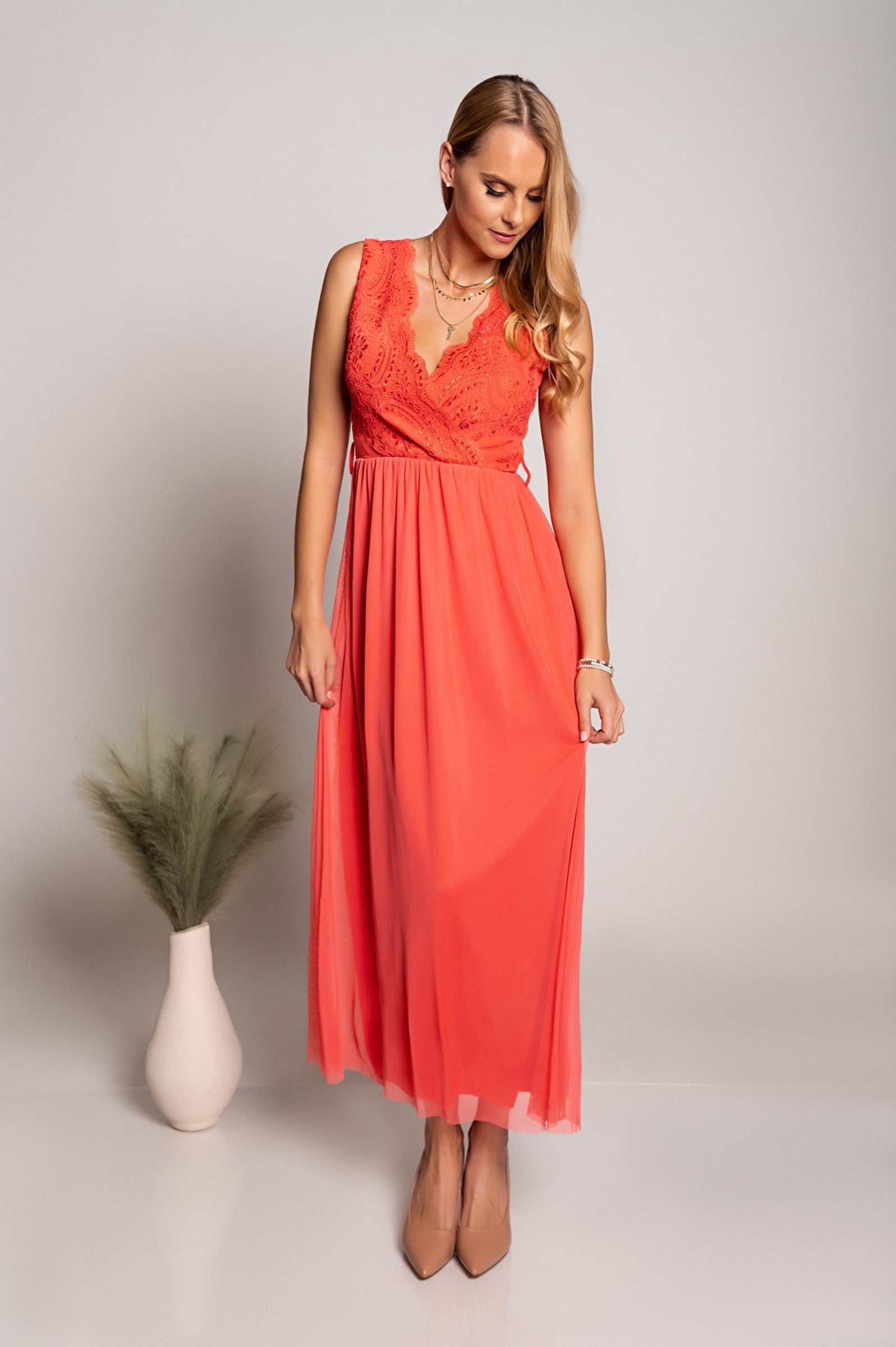 Elegantna dolga obleka z 'V' izrezom in detajlom vezenine, izdelana iz mehkega in elastičnega blaga.