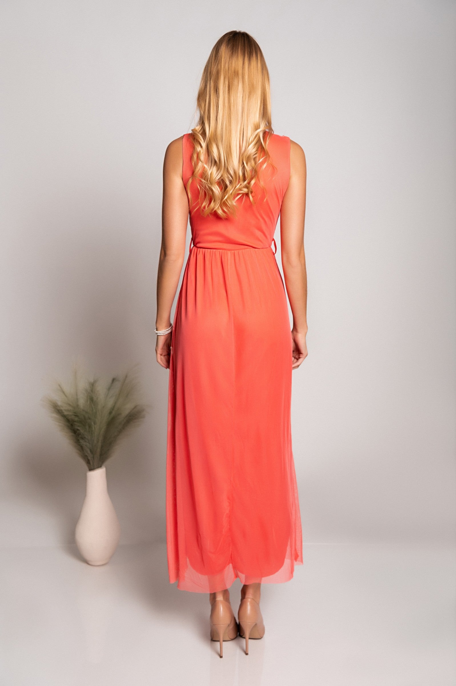 Elegantna dolga obleka z 'V' izrezom in detajlom vezenine, izdelana iz mehkega in elastičnega blaga.