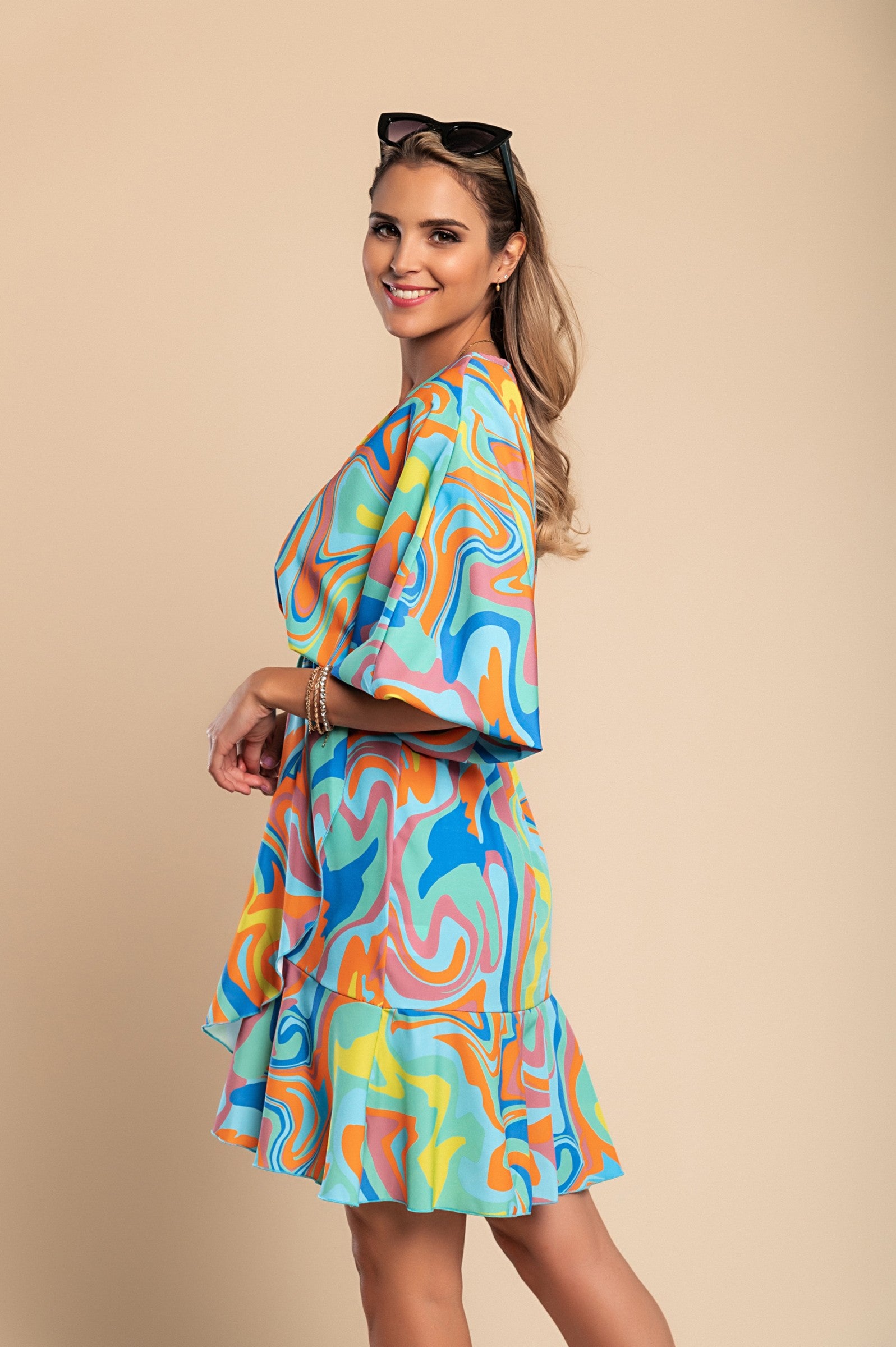 Elegantna turkizna mini obleka s potiskom Toretta, z globokim vratnim izrezom in kratkimi rokavi, zaključena z volančki.