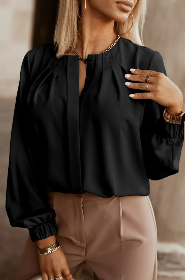 Elegantna črna srajca z okroglim ovratnikom in dolgimi rokavi z elastiko.