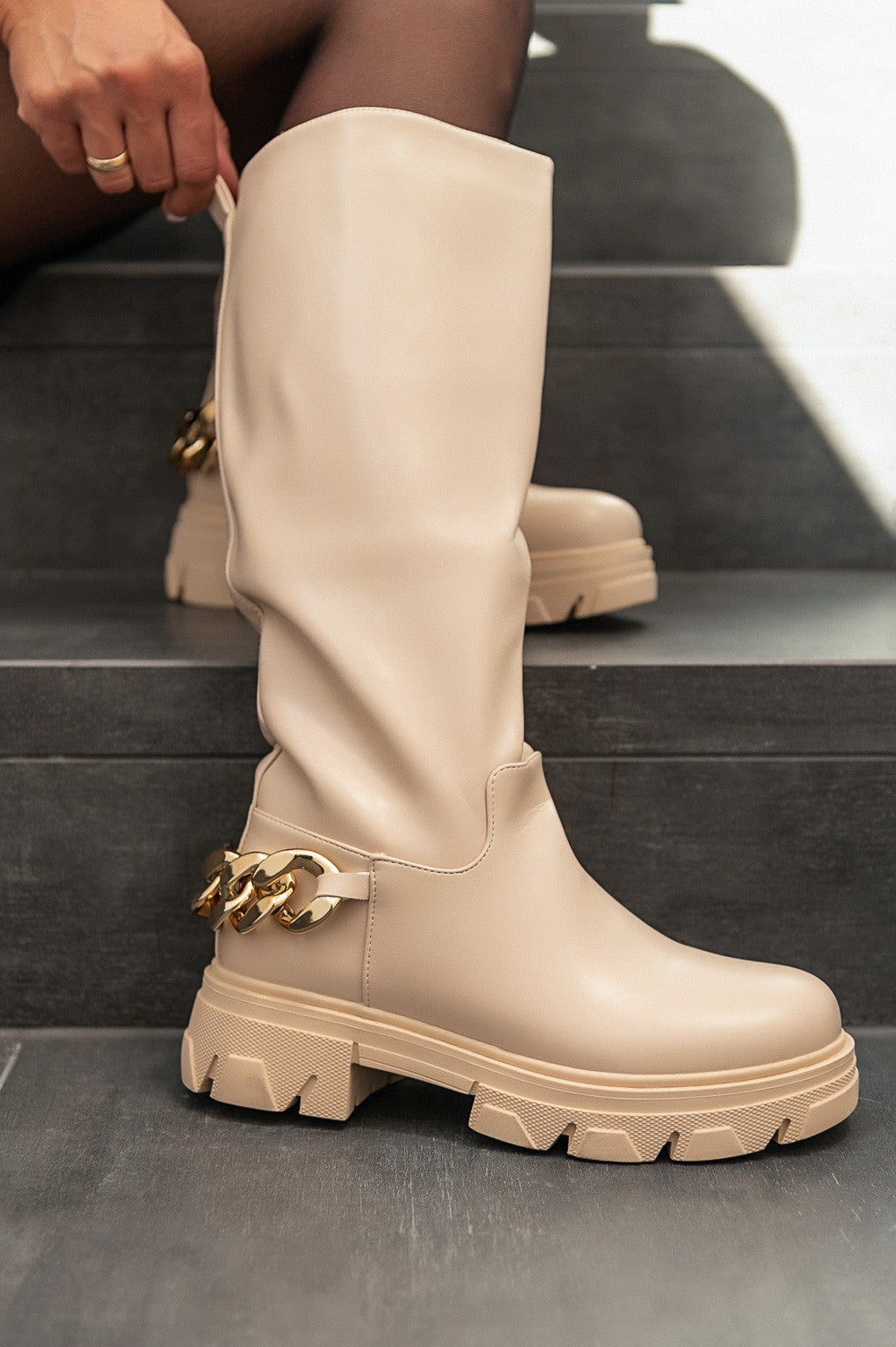 Elegantni bež škornji do kolen iz imitacije usnja z okrasno verigo in zadrgo.