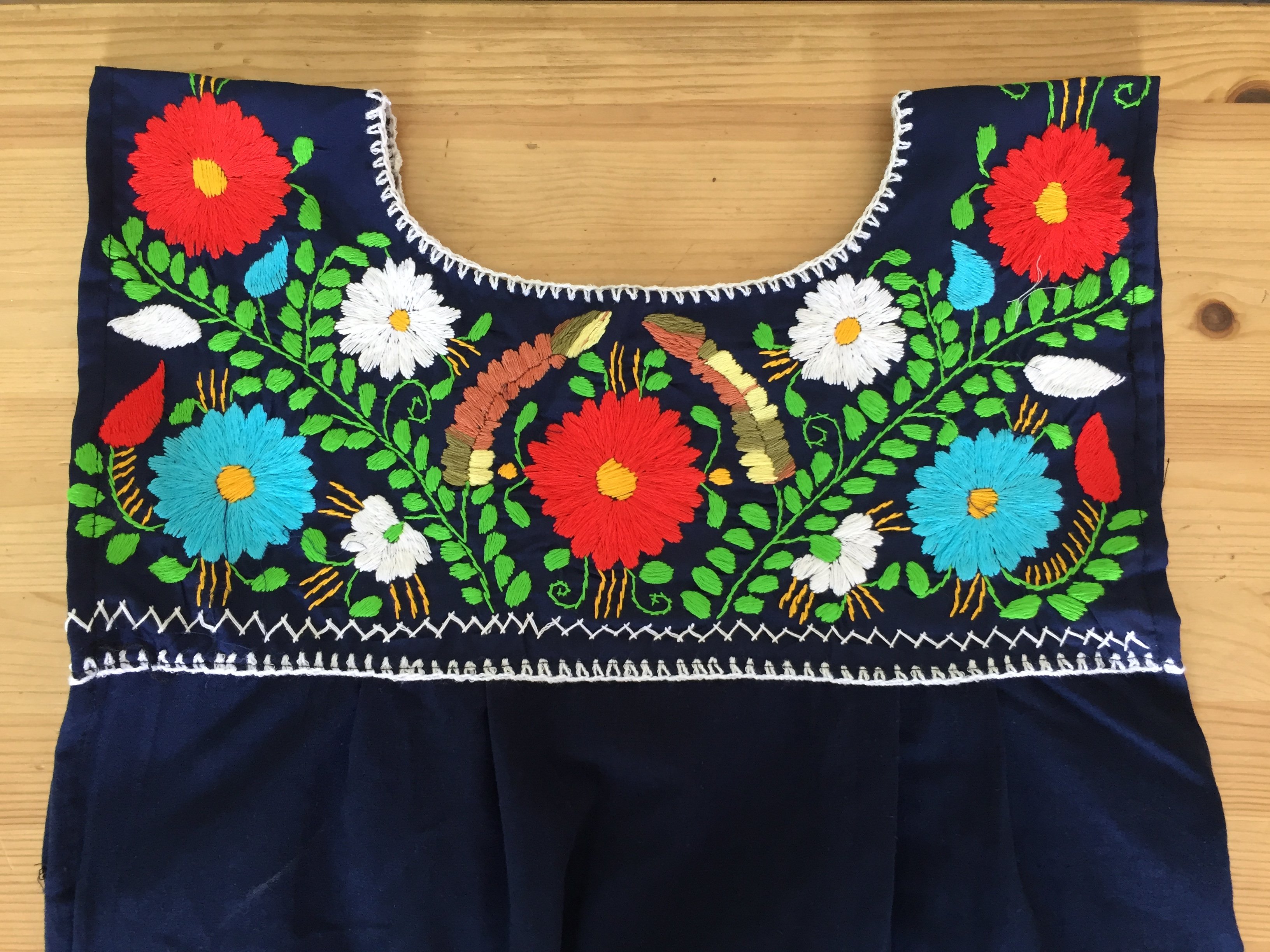 Elvira Hand Embroidered Mexican Loose Dress featuring multicolor floral embroidery on a navy blue cotton fabric, showcasing its unique craftsmanship.