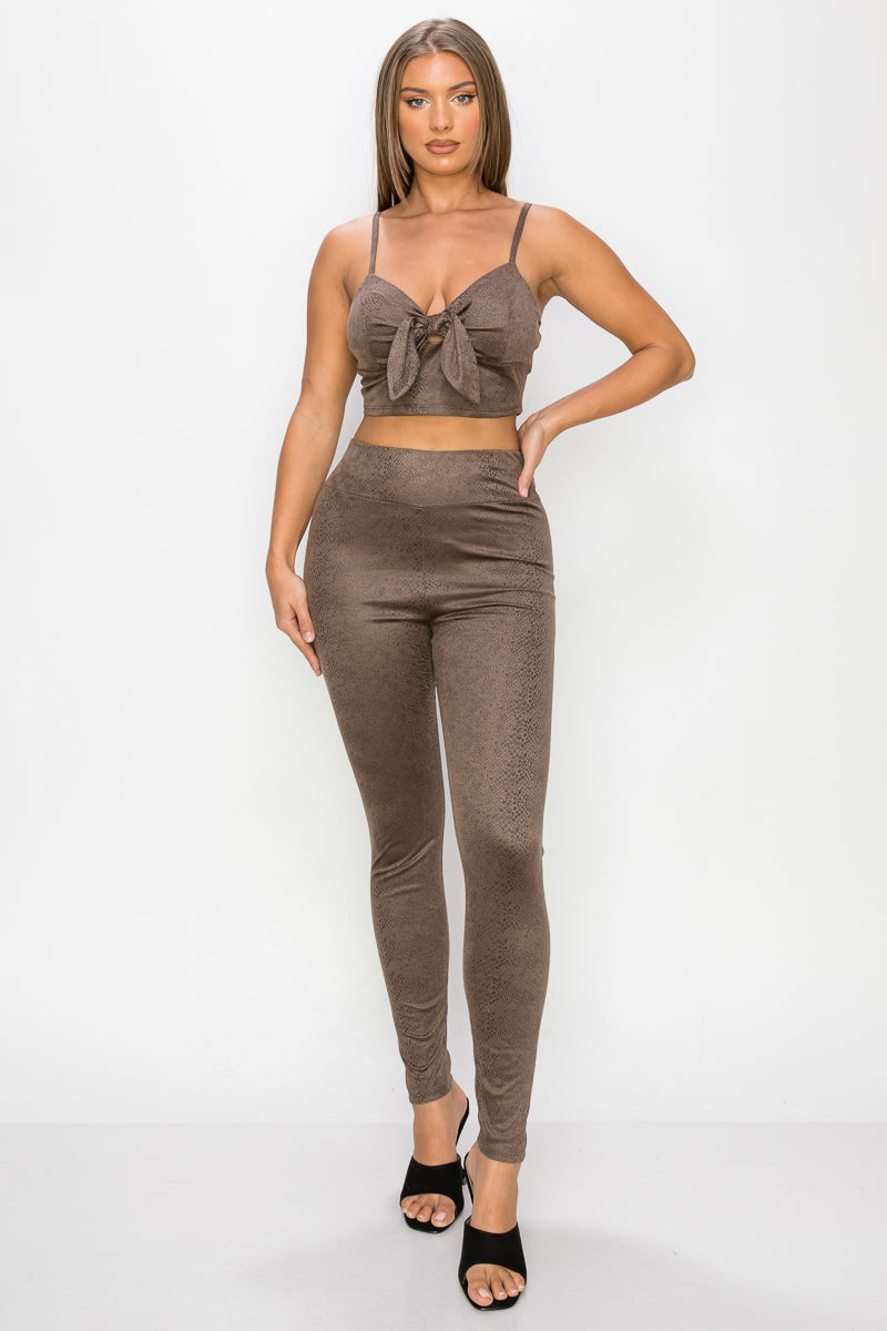A stylish embossed snake print crop top and leggings set in mocha color, featuring a front tie and adjustable straps.