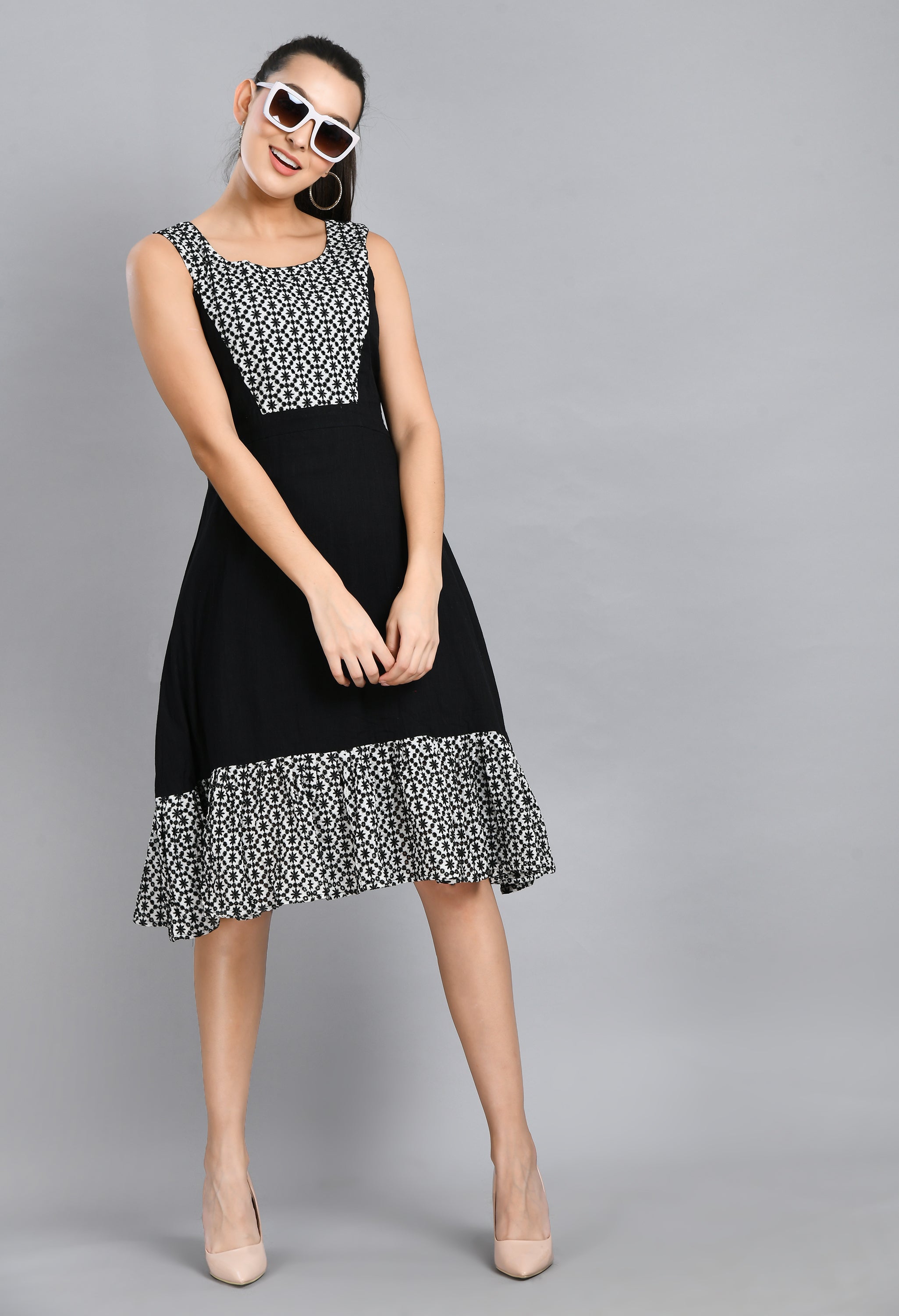 A stylish embroidered black dress featuring a square neck, sleeveless design, and asymmetrical hem, perfect for casual and semi-festive occasions.