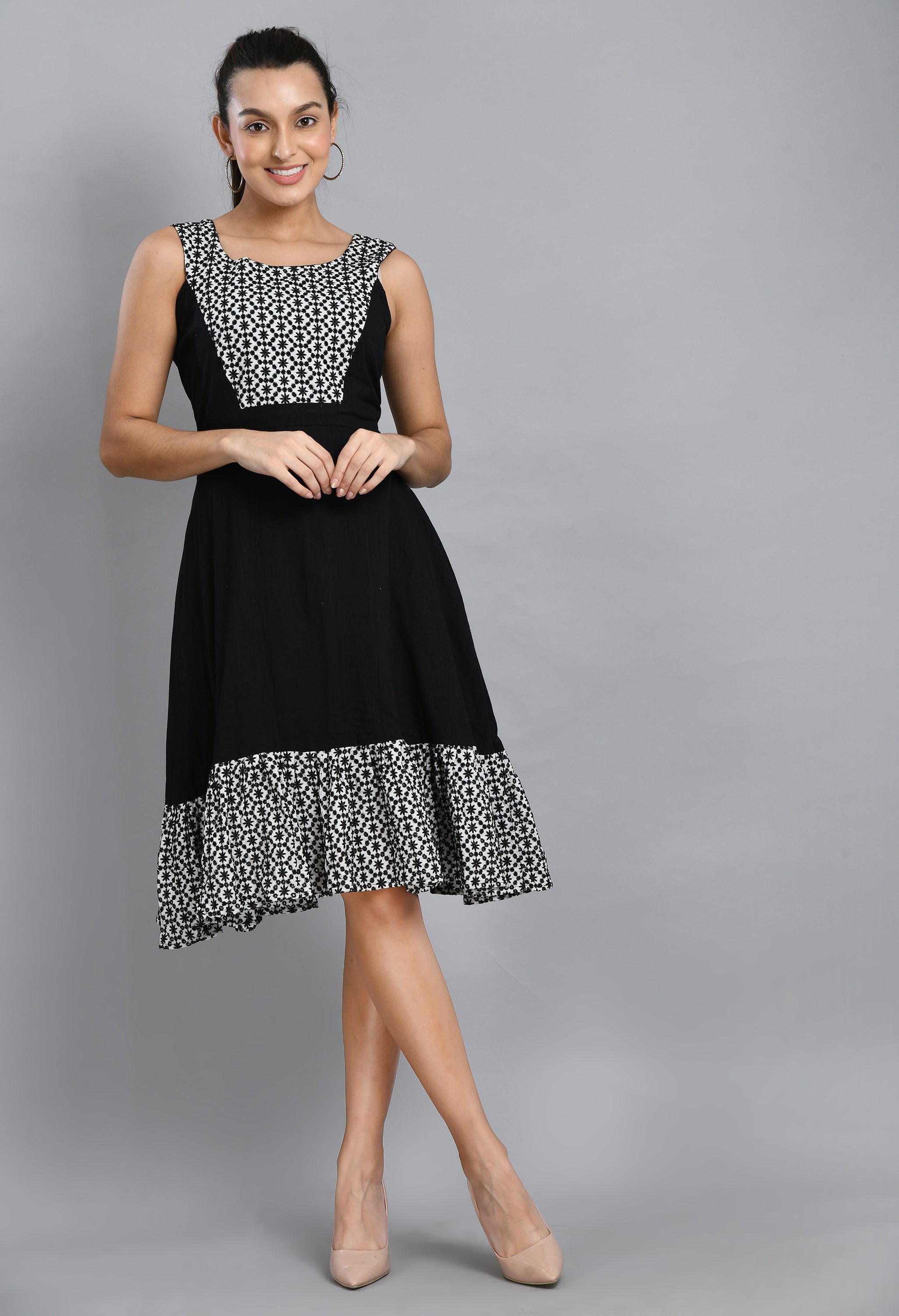A stylish embroidered black dress featuring a square neck, sleeveless design, and asymmetrical hem, perfect for casual and semi-festive occasions.