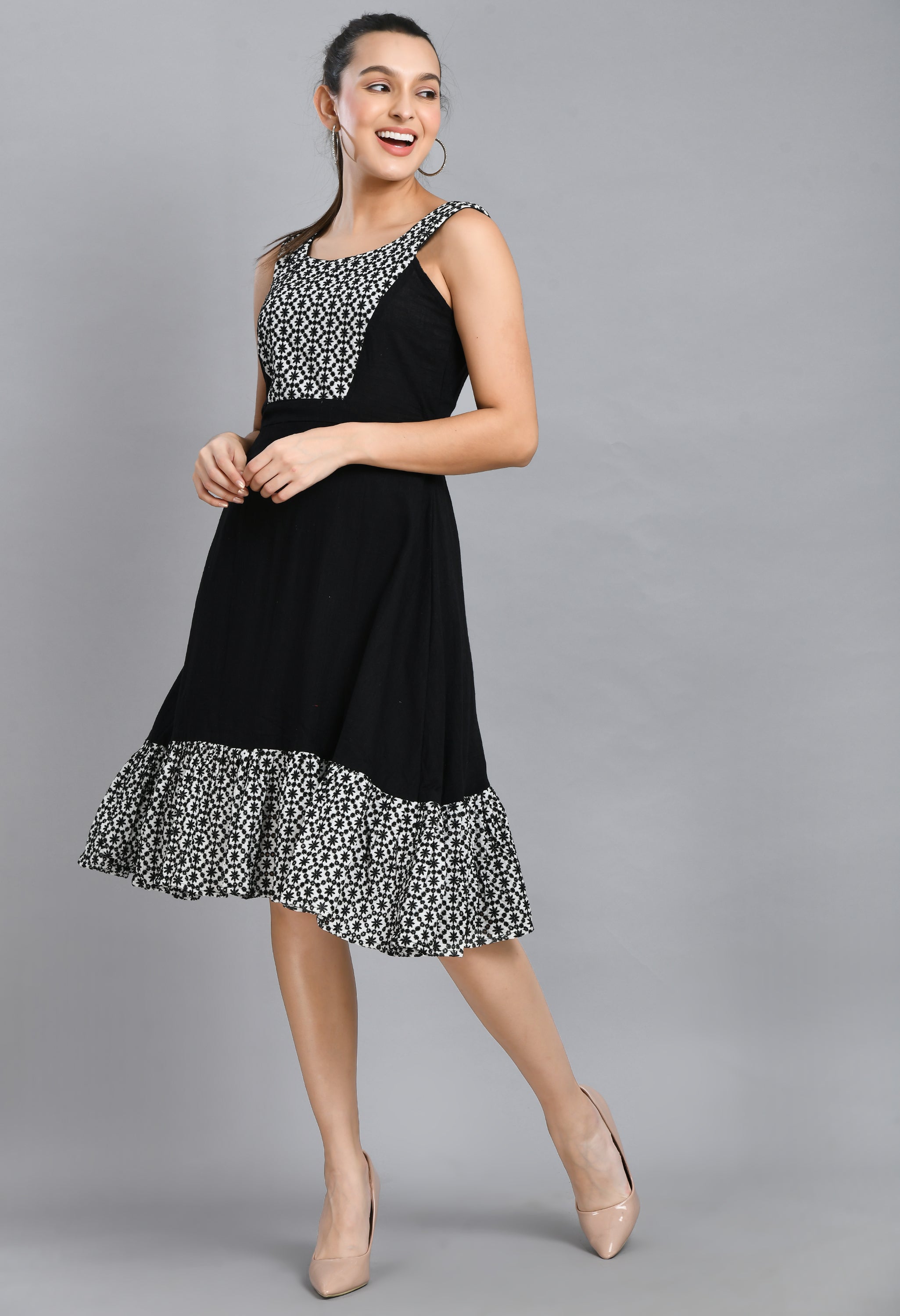 A stylish embroidered black dress featuring a square neck, sleeveless design, and asymmetrical hem, perfect for casual and semi-festive occasions.