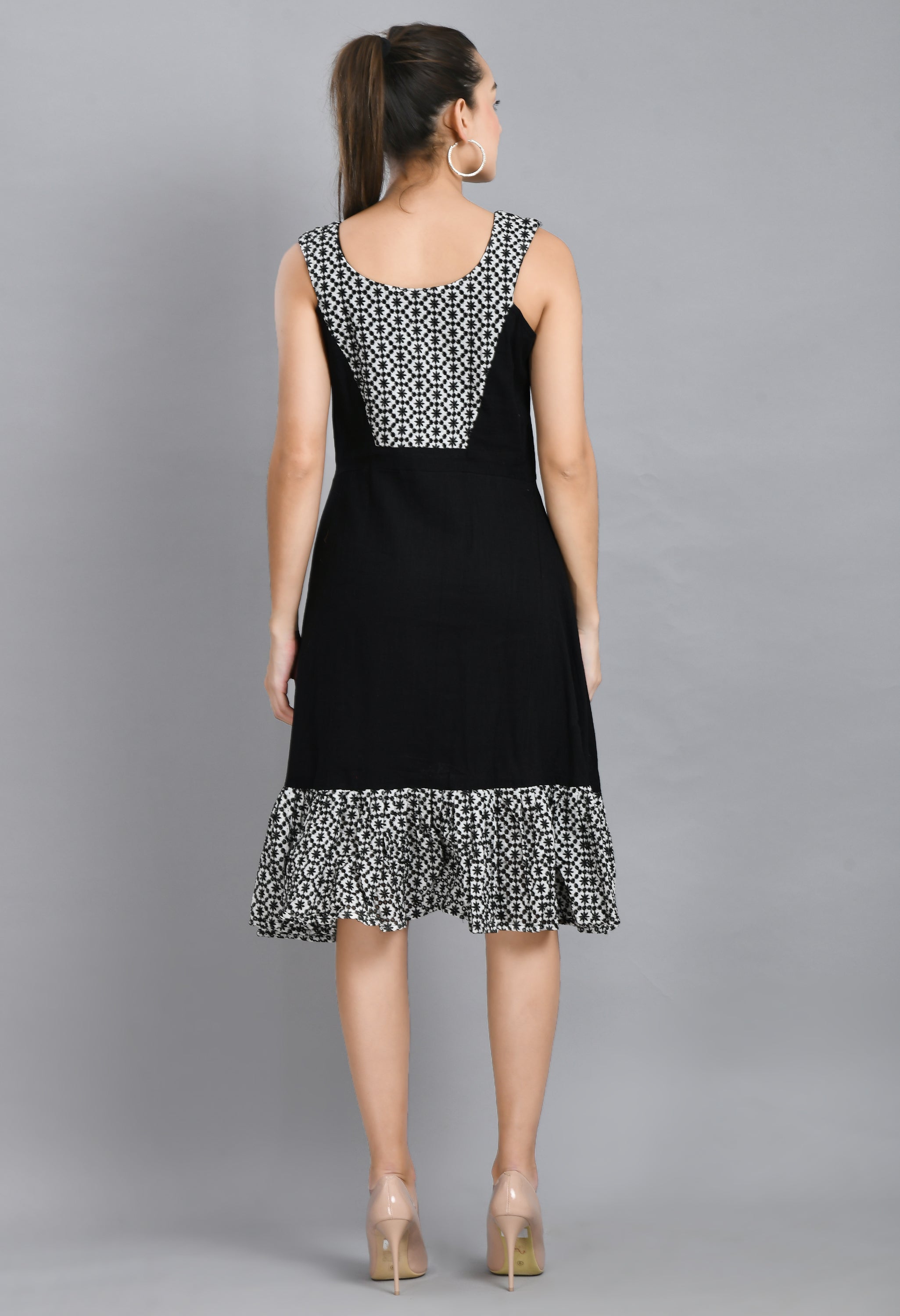 A stylish embroidered black dress featuring a square neck, sleeveless design, and asymmetrical hem, perfect for casual and semi-festive occasions.