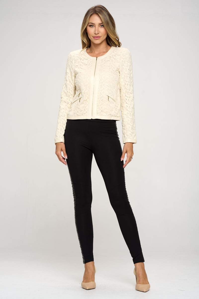 Embroidered zip-up jacket featuring zipper pockets and vegan leather edging, modeled by a woman standing confidently.