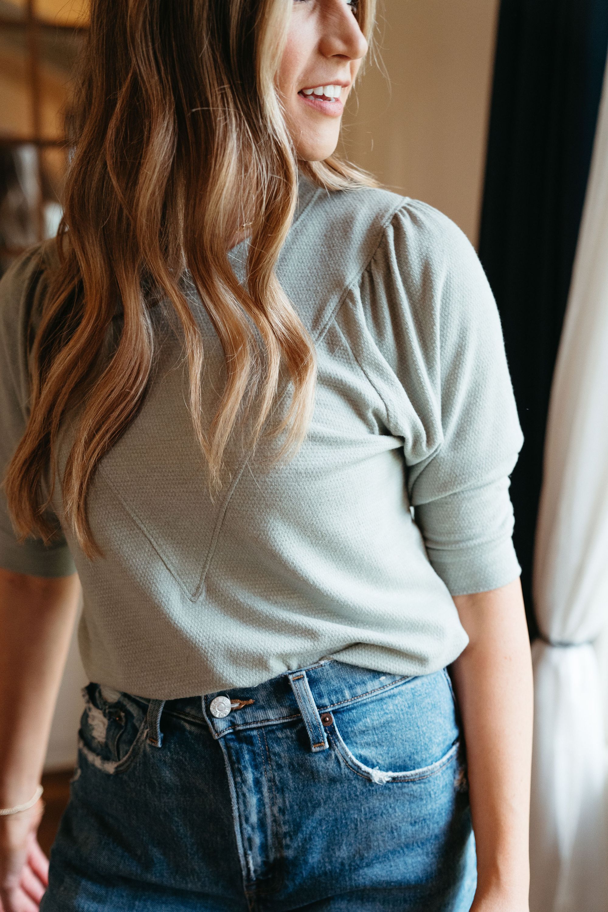 Emily Soft Top in Sage featuring puff sleeves and textured v-shape design, perfect for layering in spring.