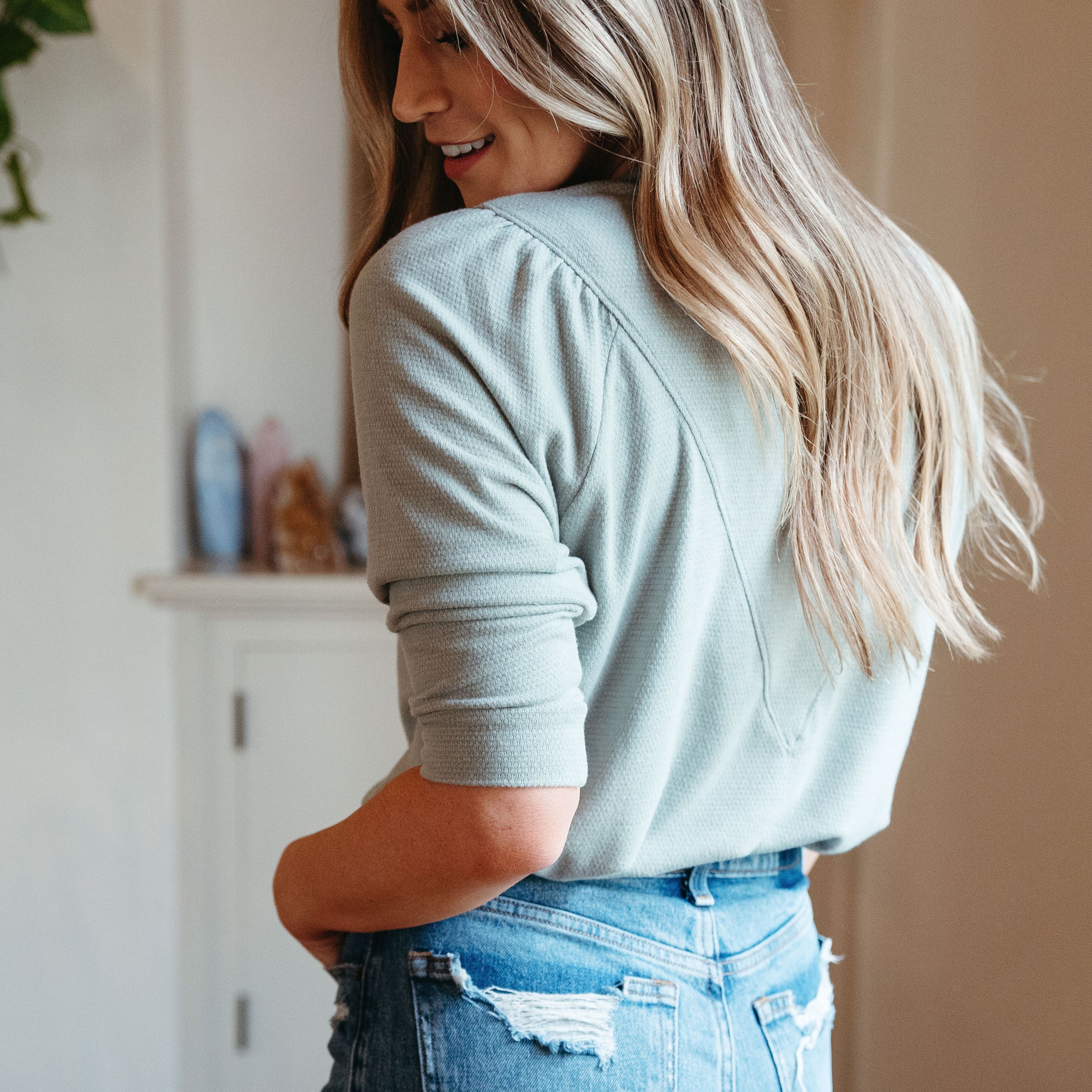 Emily Soft Top in Sage featuring puff sleeves and textured v-shape design, perfect for layering in spring.