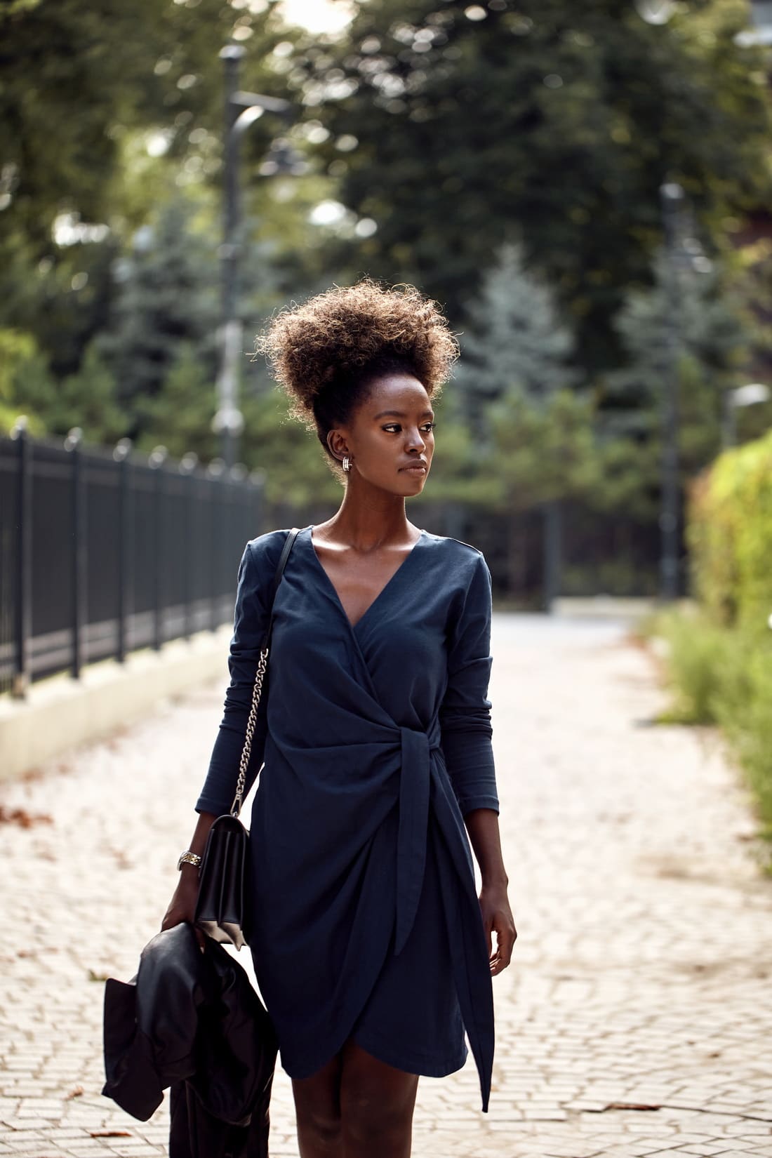 Navy blue envelope dress featuring an asymmetrical bottom, V-neckline, and long tapered sleeves, perfect for various occasions.