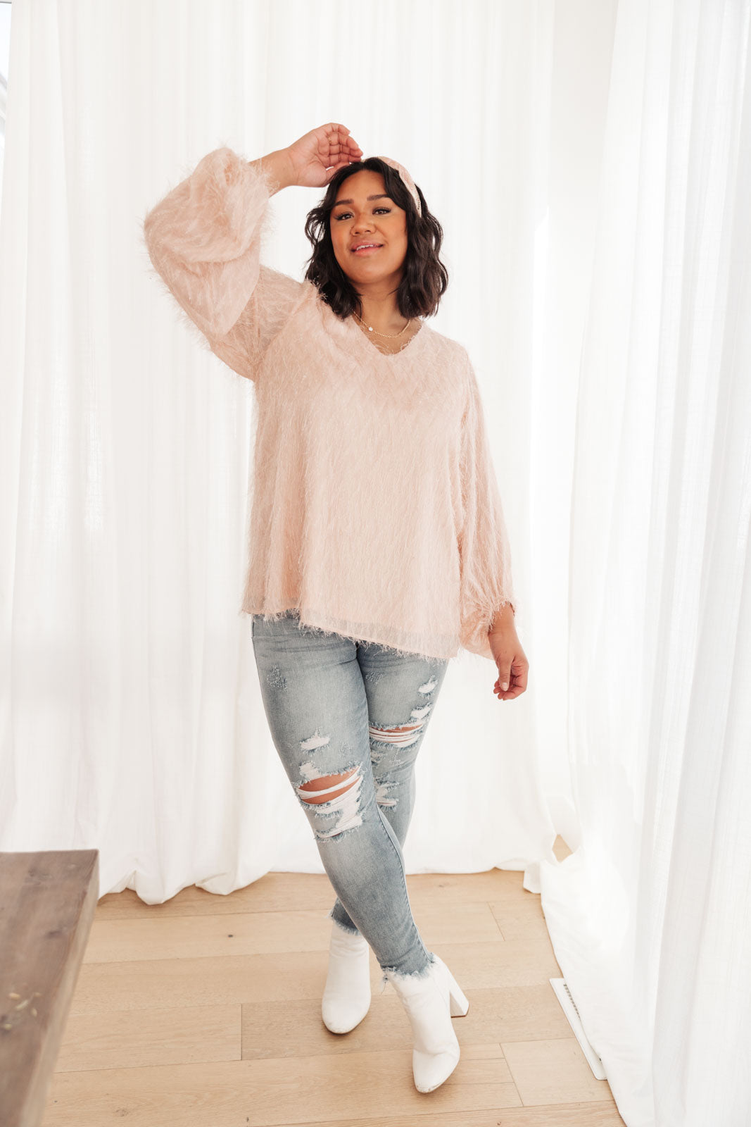 A stylish peach textured blouse with oversized long sleeves and a v-neck, perfect for parties and events.