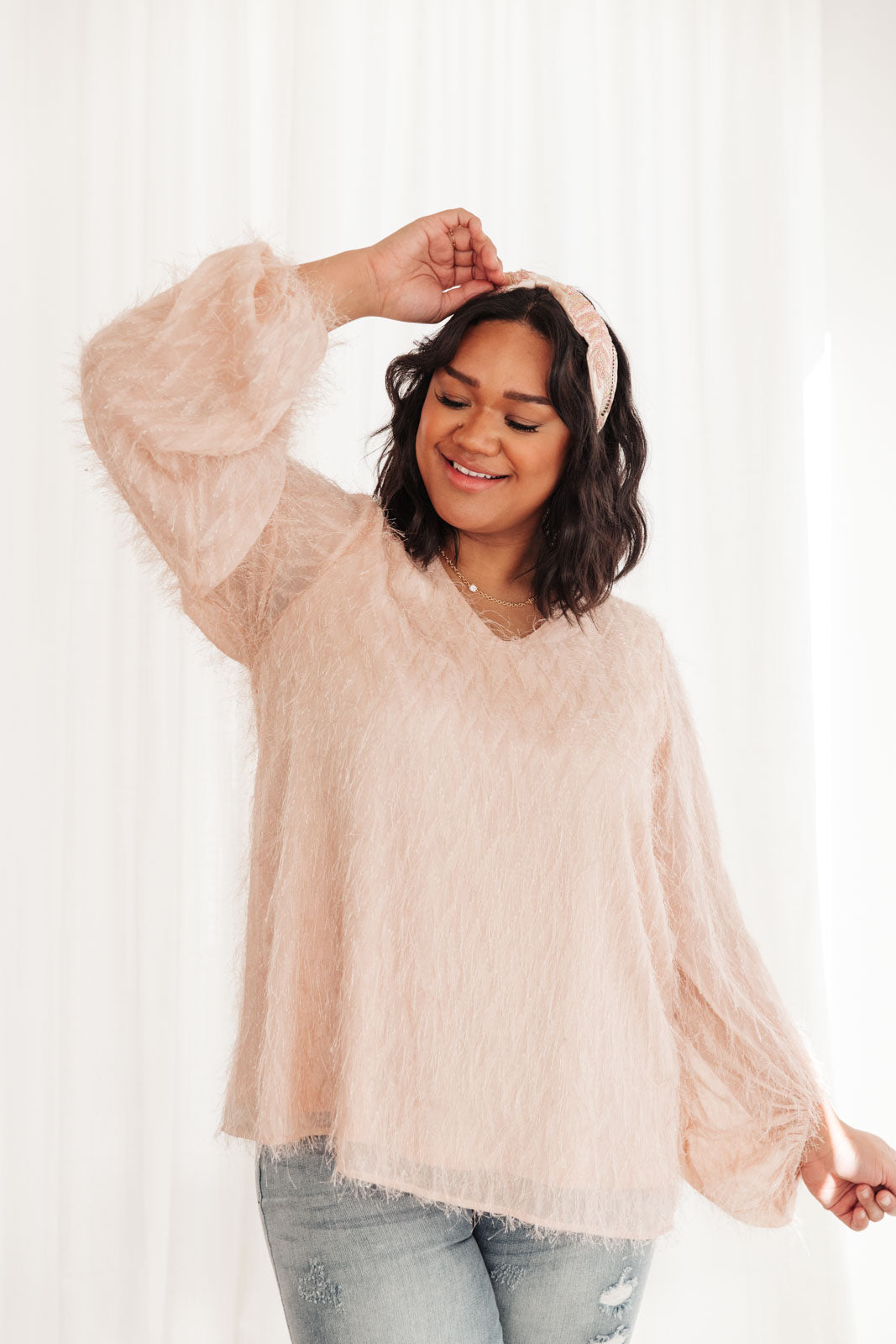 A stylish peach textured blouse with oversized long sleeves and a v-neck, perfect for parties and events.