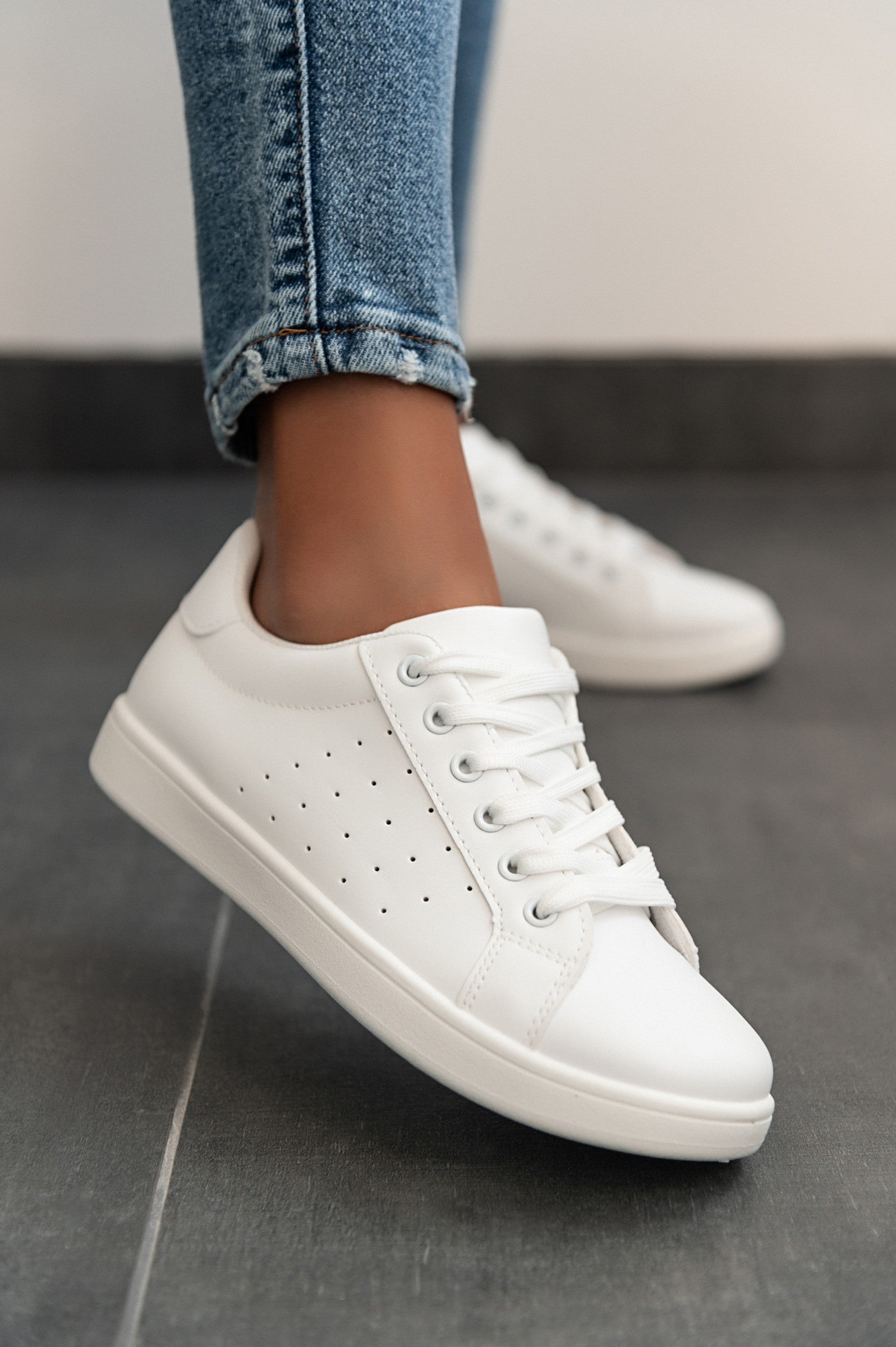 A pair of stylish white fashion sneakers with flat sole, featuring a round toe and lace-up closure, made from high-quality synthetic leather.