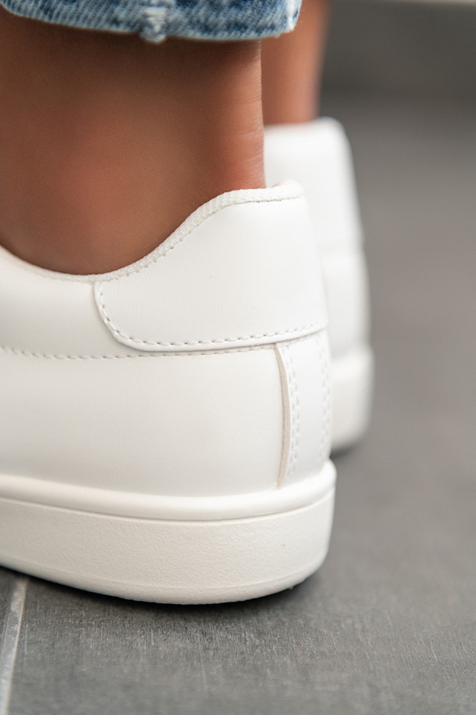 A pair of stylish white fashion sneakers with flat sole, featuring a round toe and lace-up closure, made from high-quality synthetic leather.