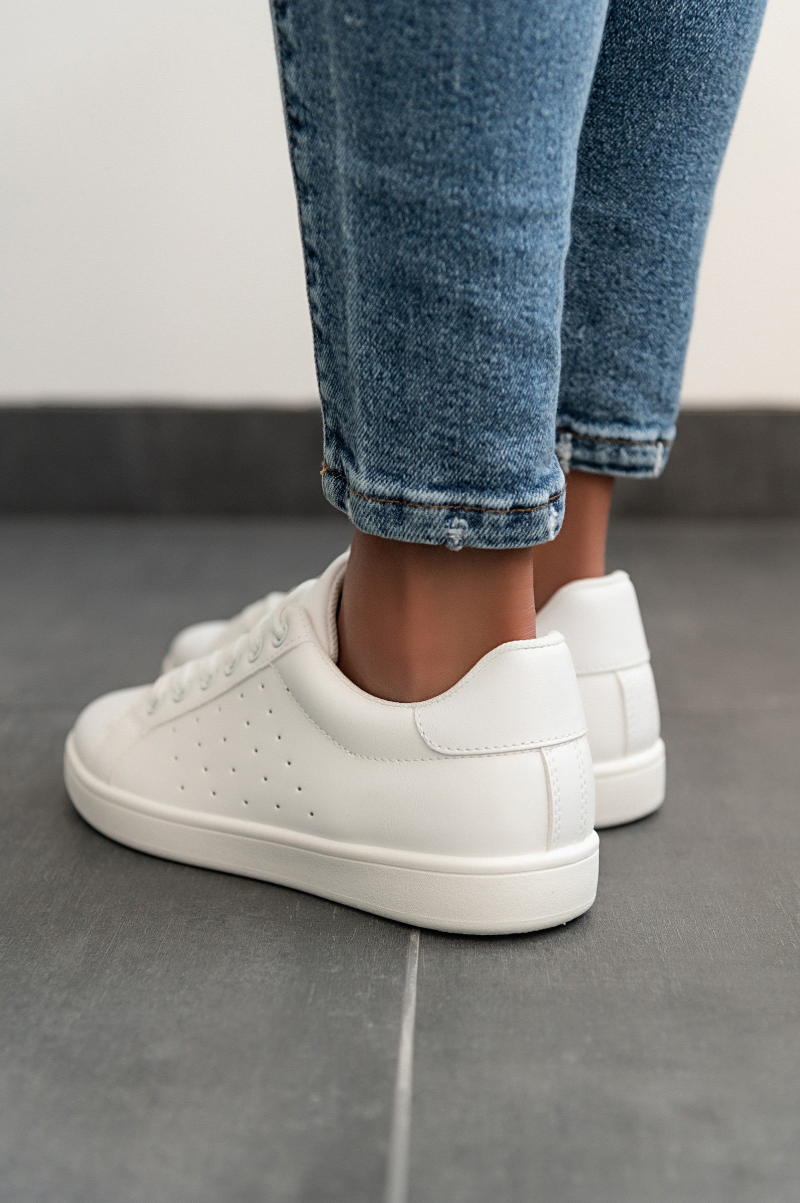 A pair of stylish white fashion sneakers with flat sole, featuring a round toe and lace-up closure, made from high-quality synthetic leather.