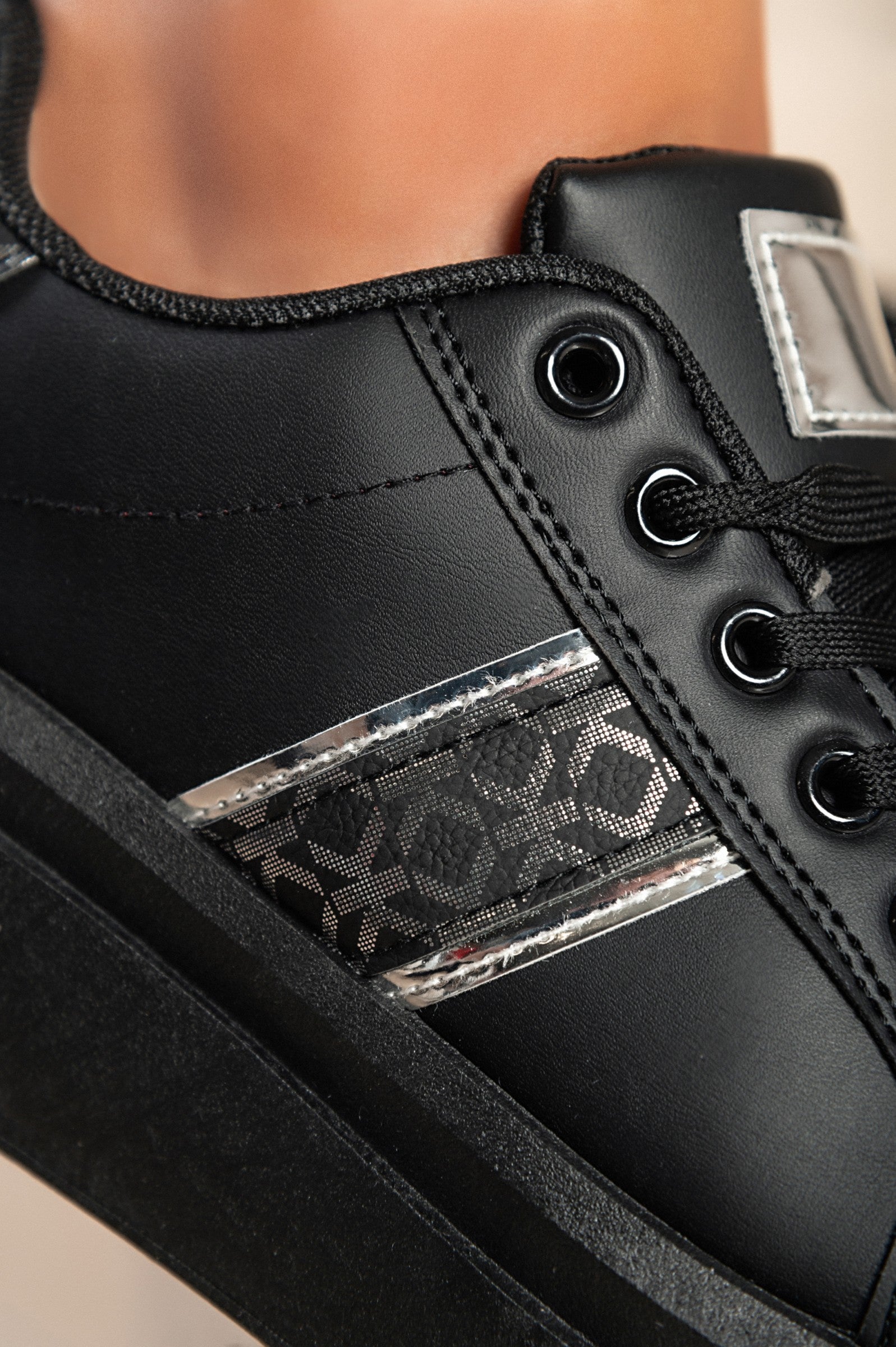 Black fashion sneakers with flat sole, lace-up closure, and round toe design, made of high-quality faux leather.