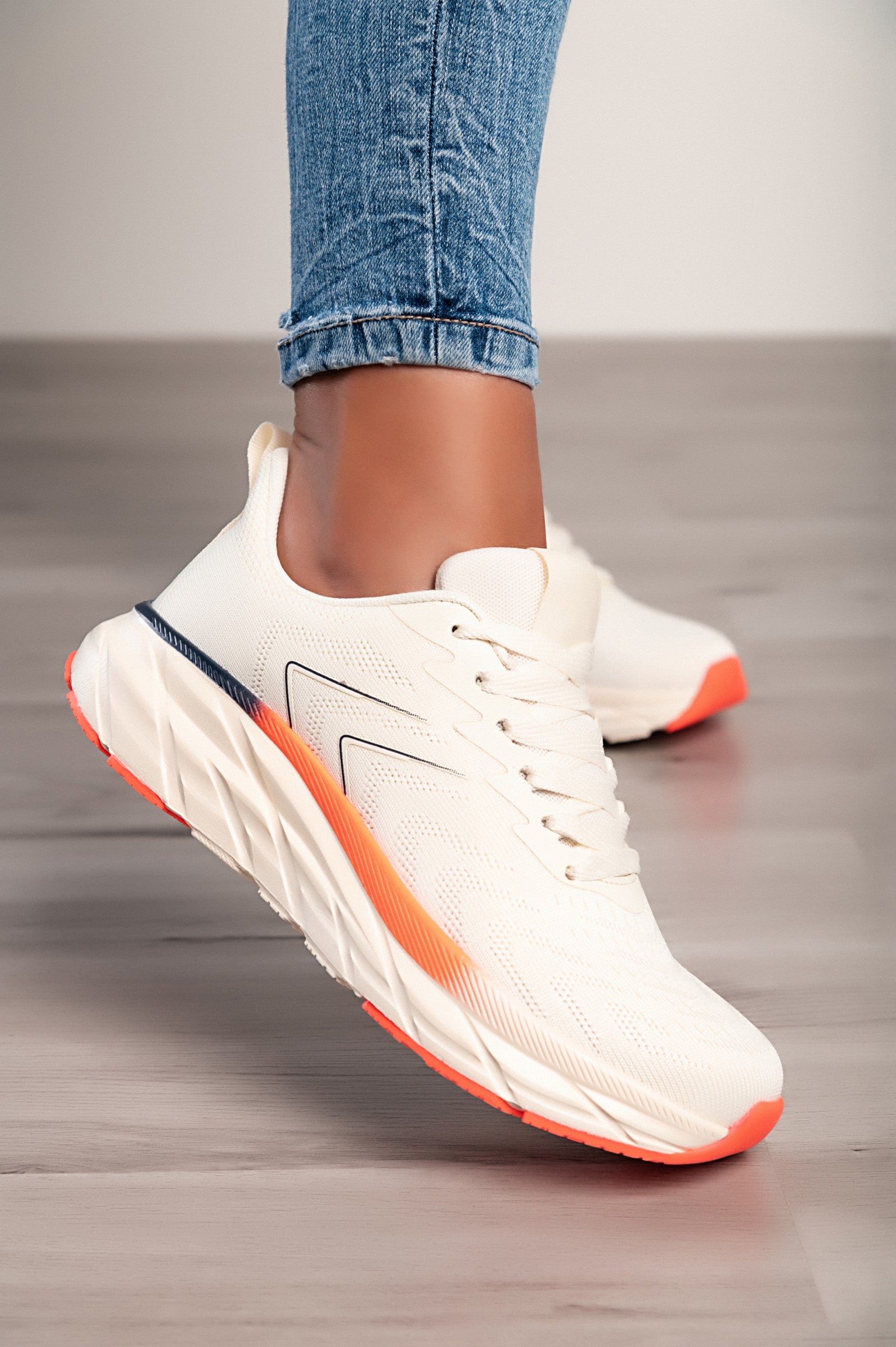 A pair of fashionable beige trainers featuring a textile upper, round toe, and reinforced heel and toe, perfect for stylish comfort.