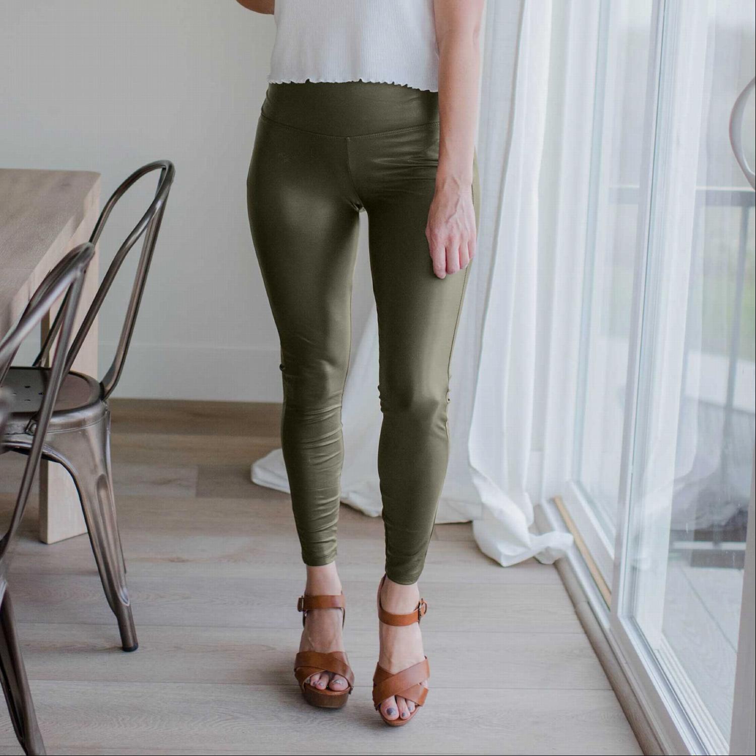 A pair of stylish faux leather leggings with a comfortable waist band, showcasing their sleek design and stretchy fabric.