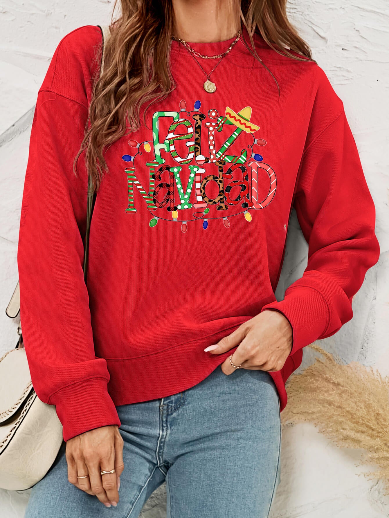 Feliz Navidad Graphic Crewneck Sweatshirt in a studio setting, featuring a festive design and casual style.