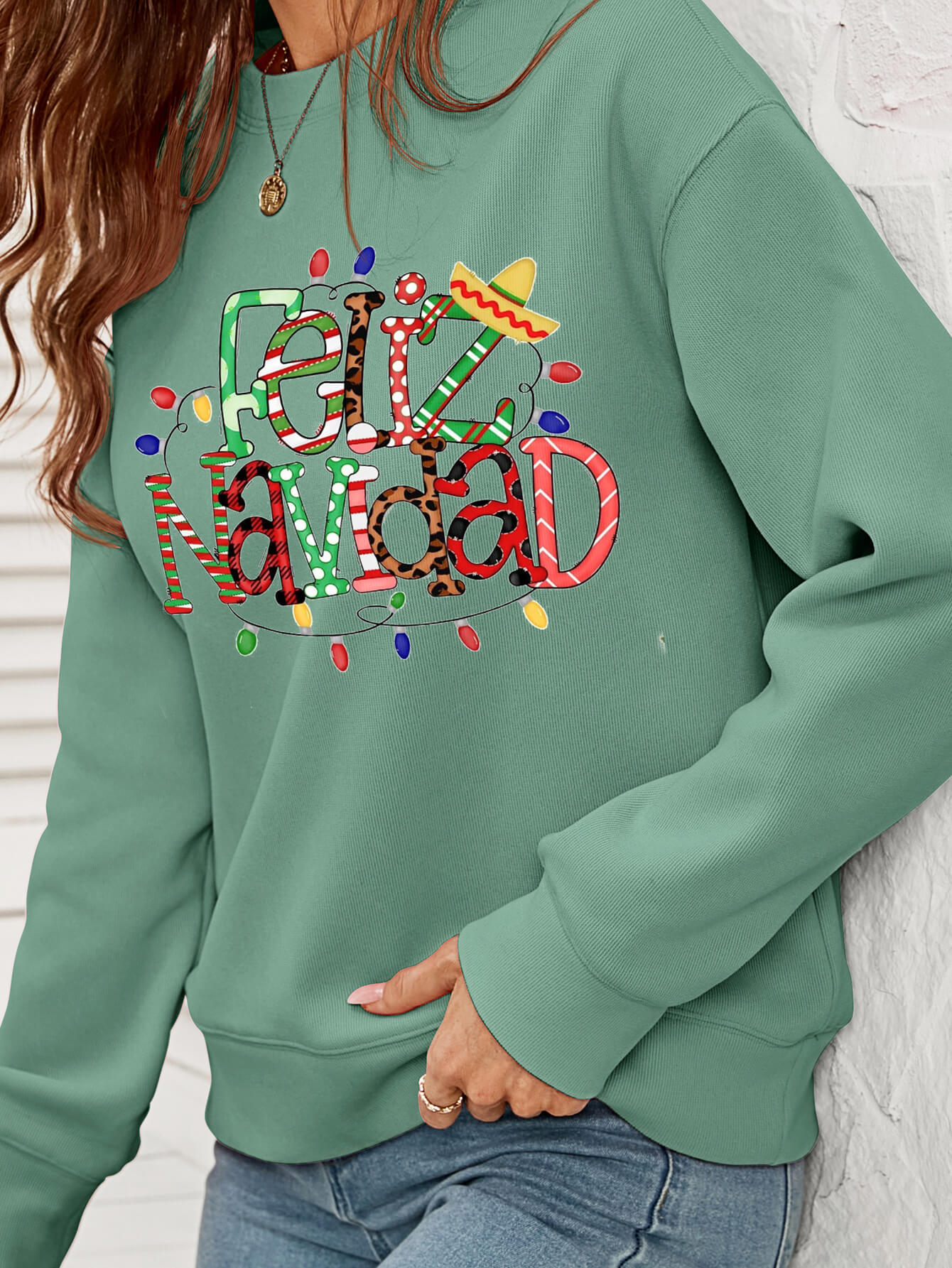 Feliz Navidad Graphic Crewneck Sweatshirt in a studio setting, featuring a festive design and casual style.