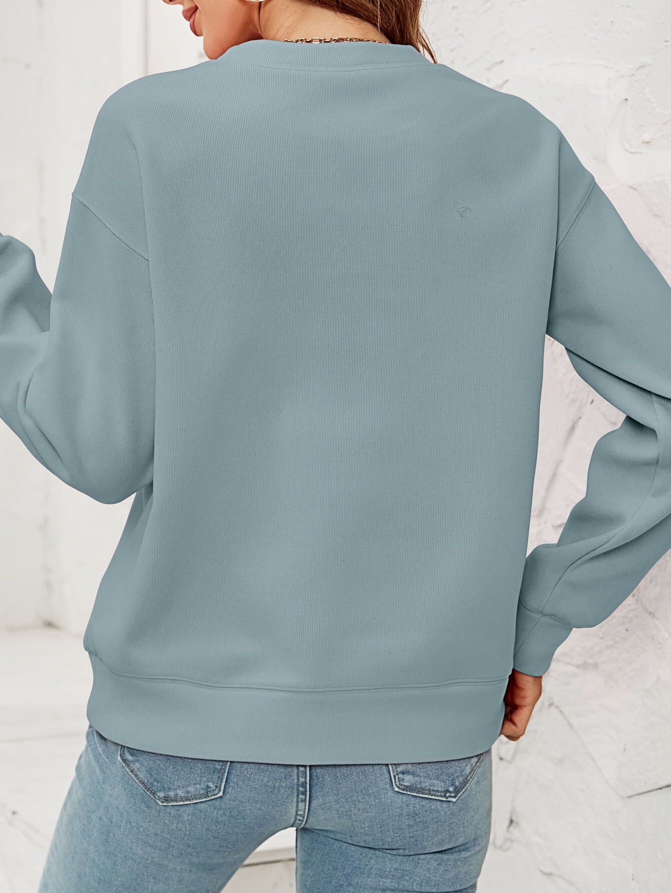 Feliz Navidad Graphic Crewneck Sweatshirt in a studio setting, featuring a festive design and casual style.