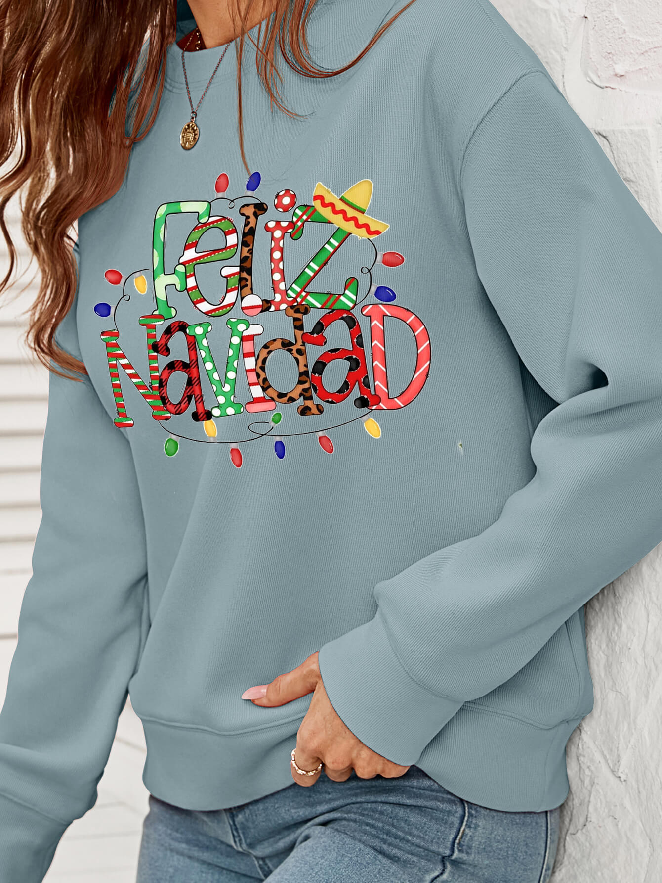 Feliz Navidad Graphic Crewneck Sweatshirt in a studio setting, featuring a festive design and casual style.