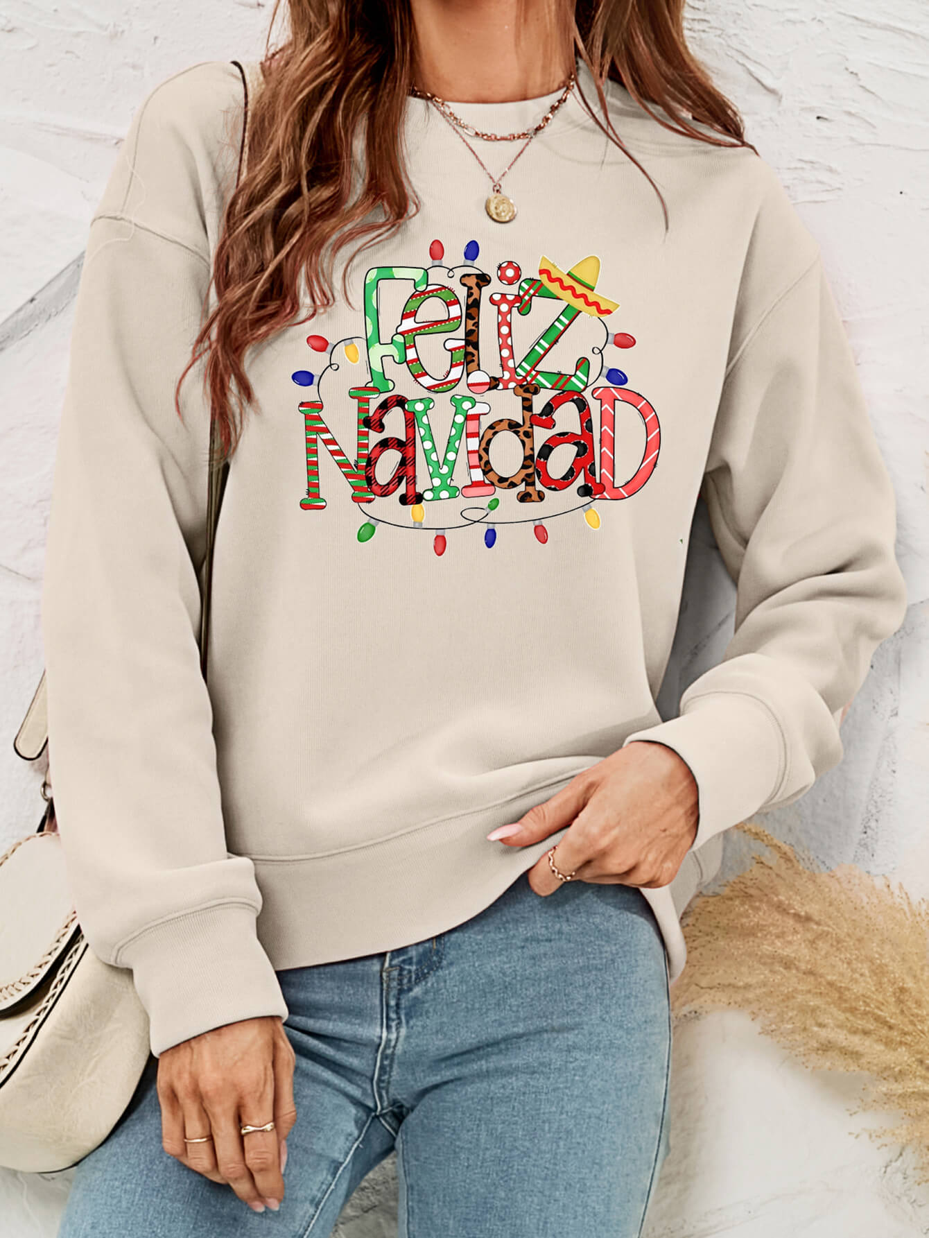 Feliz Navidad Graphic Crewneck Sweatshirt in a studio setting, featuring a festive design and casual style.