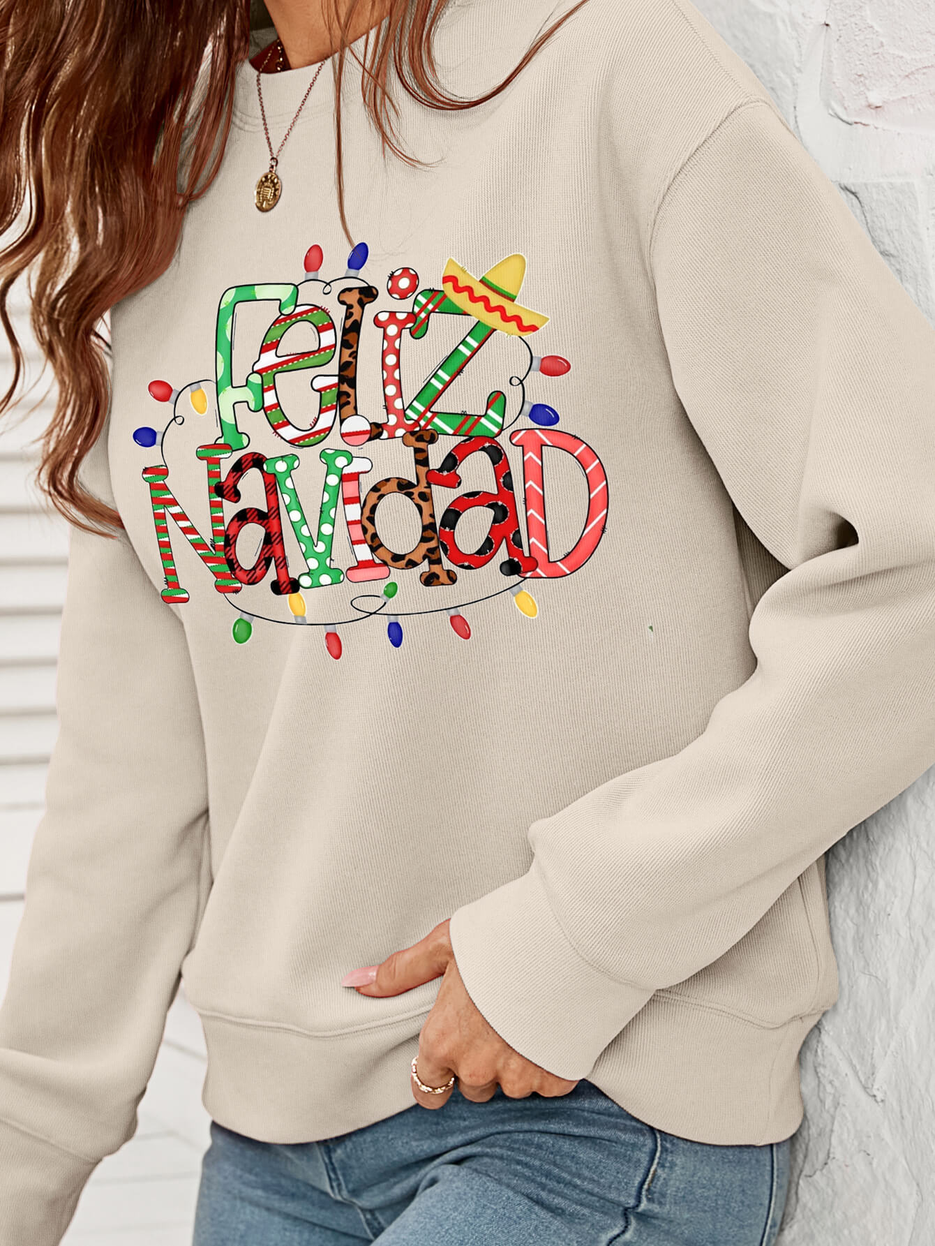 Feliz Navidad Graphic Crewneck Sweatshirt in a studio setting, featuring a festive design and casual style.