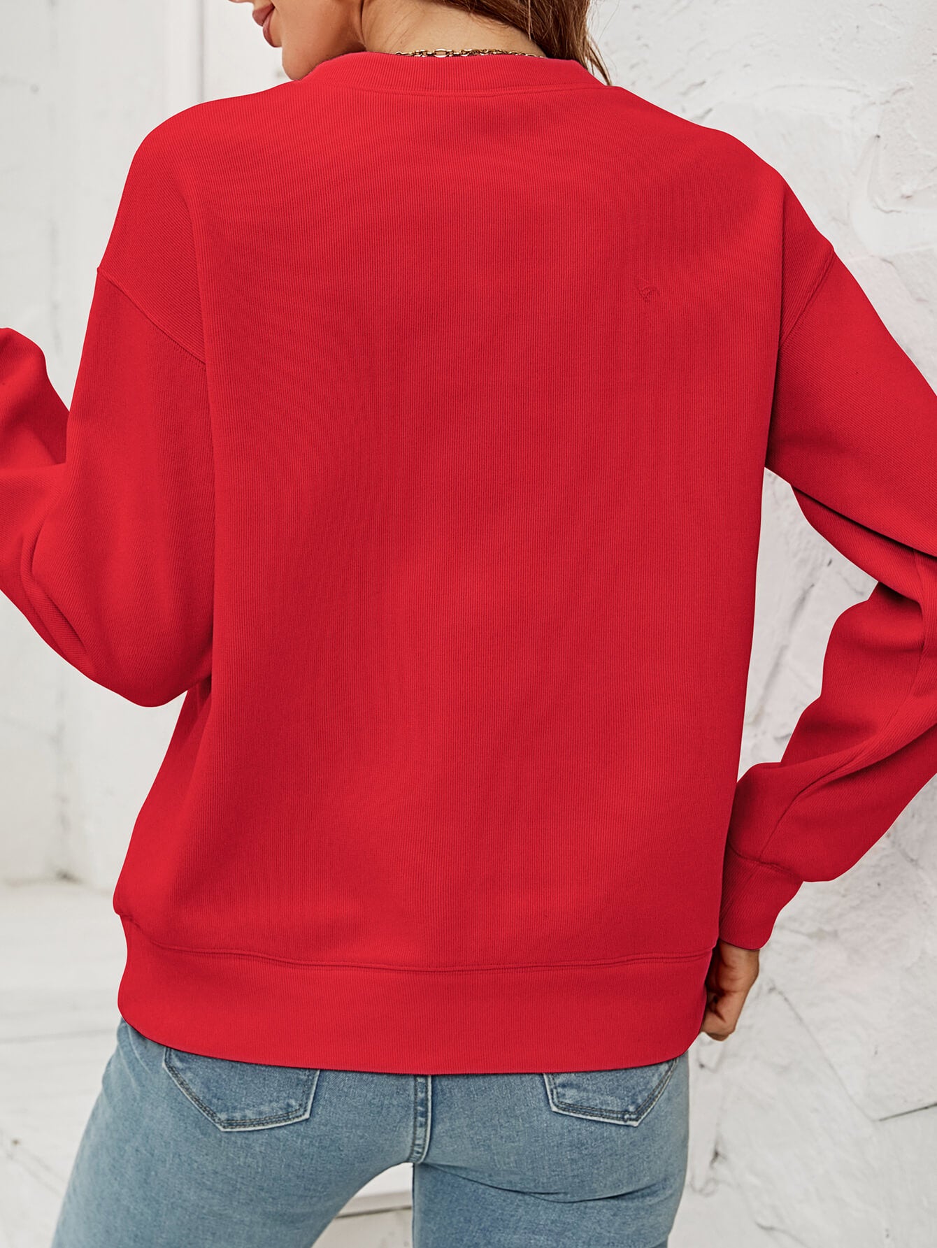 Feliz Navidad Graphic Crewneck Sweatshirt in a studio setting, featuring a festive design and casual style.