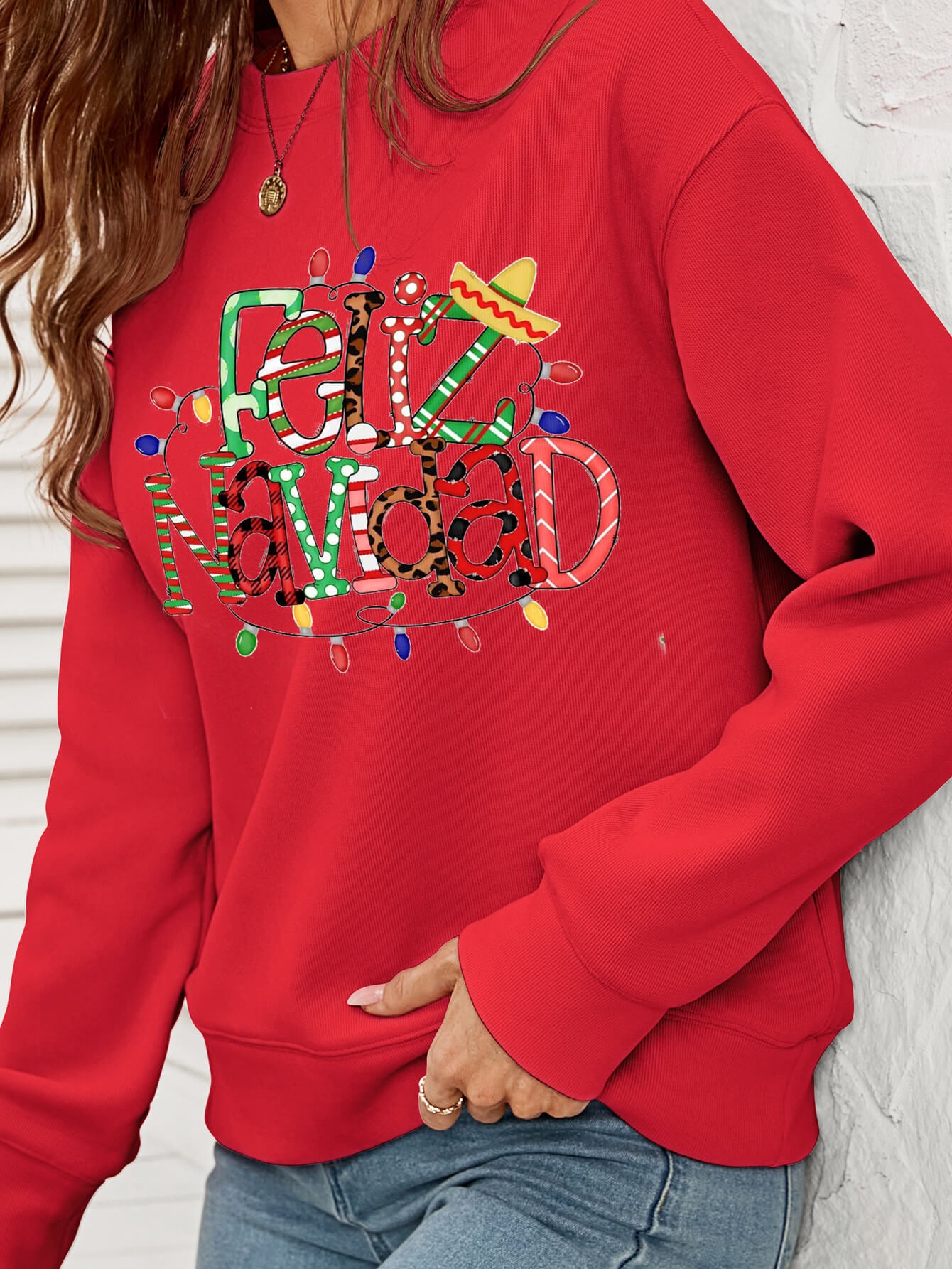 Feliz Navidad Graphic Crewneck Sweatshirt in a studio setting, featuring a festive design and casual style.